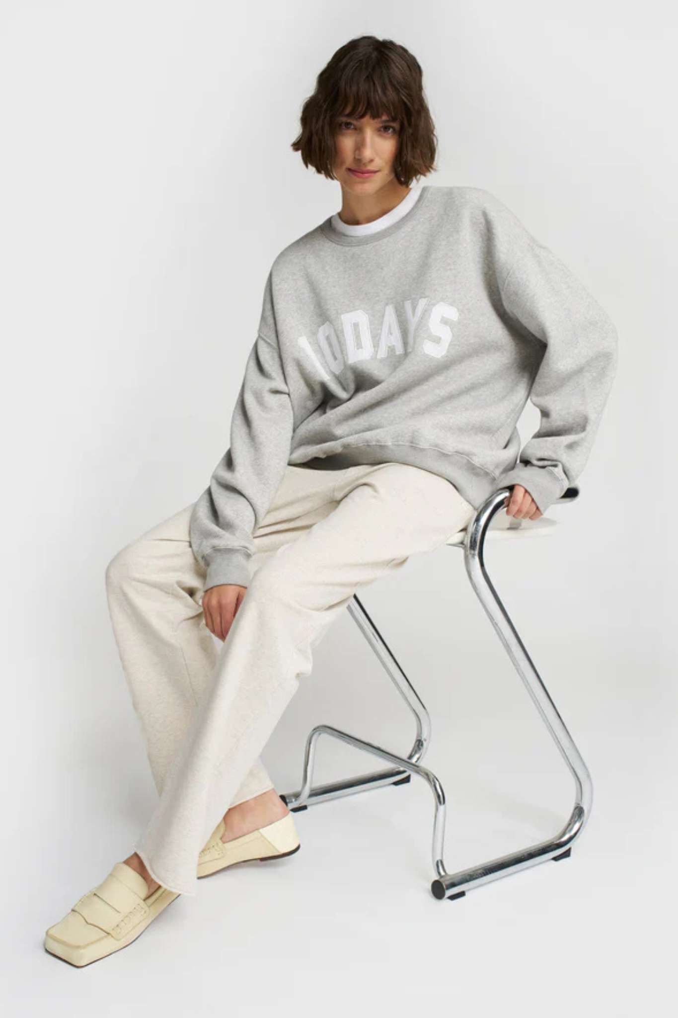 Model wearing the 10DAYS statement sweater in light grey melange. Front view