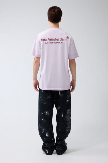 Model wearing the New Amsterdam orchid t-shirt with logo in red. Back view