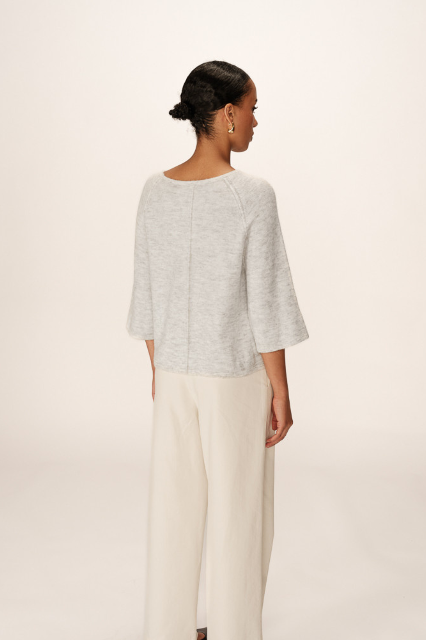 Model wearing the Grace & Mila paco sweater in grey. Back view