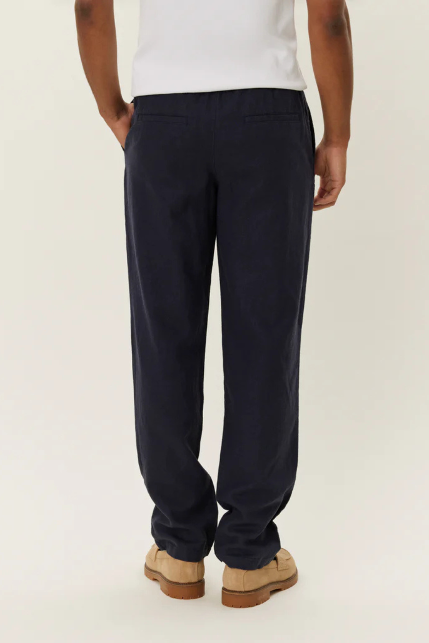 Model wearing the Les Deux patrick linen pants in dark navy. Back view