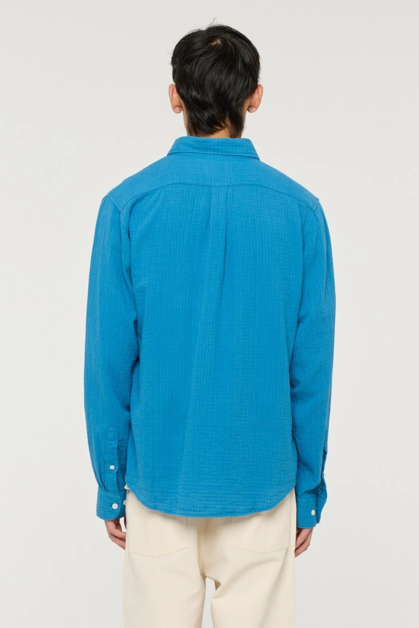 Model wearing the Castart konga shirt in bright blue. Back view