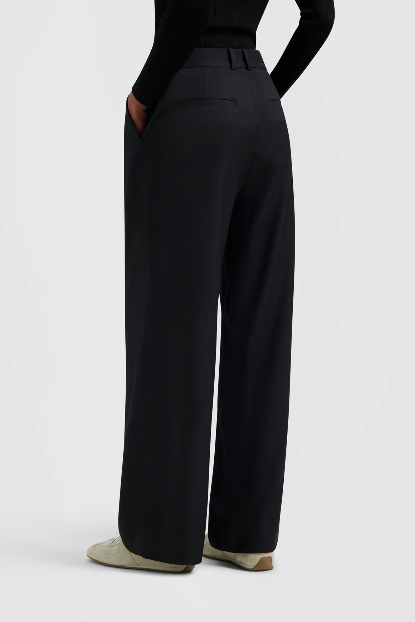 Model wearing the Olaf tailored trousers in black. Back view