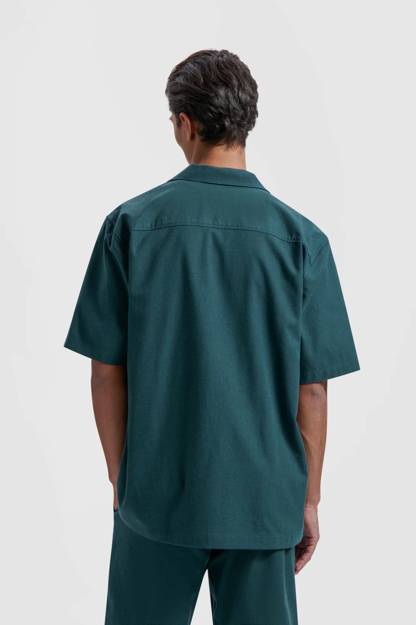 Model wearing the Olaf linen camp shirt in green. Back view