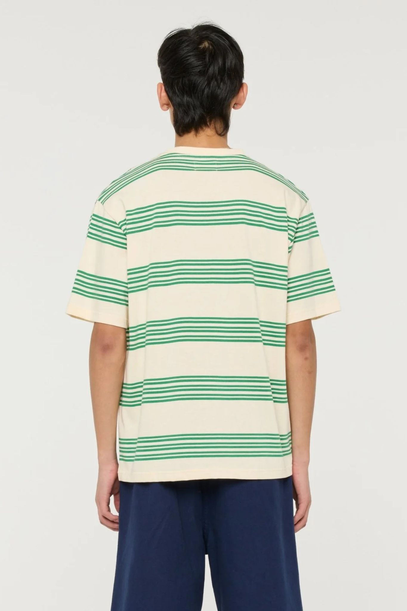 Model wearing the Castart haruto striped t-shirt in green and ecru. Back view