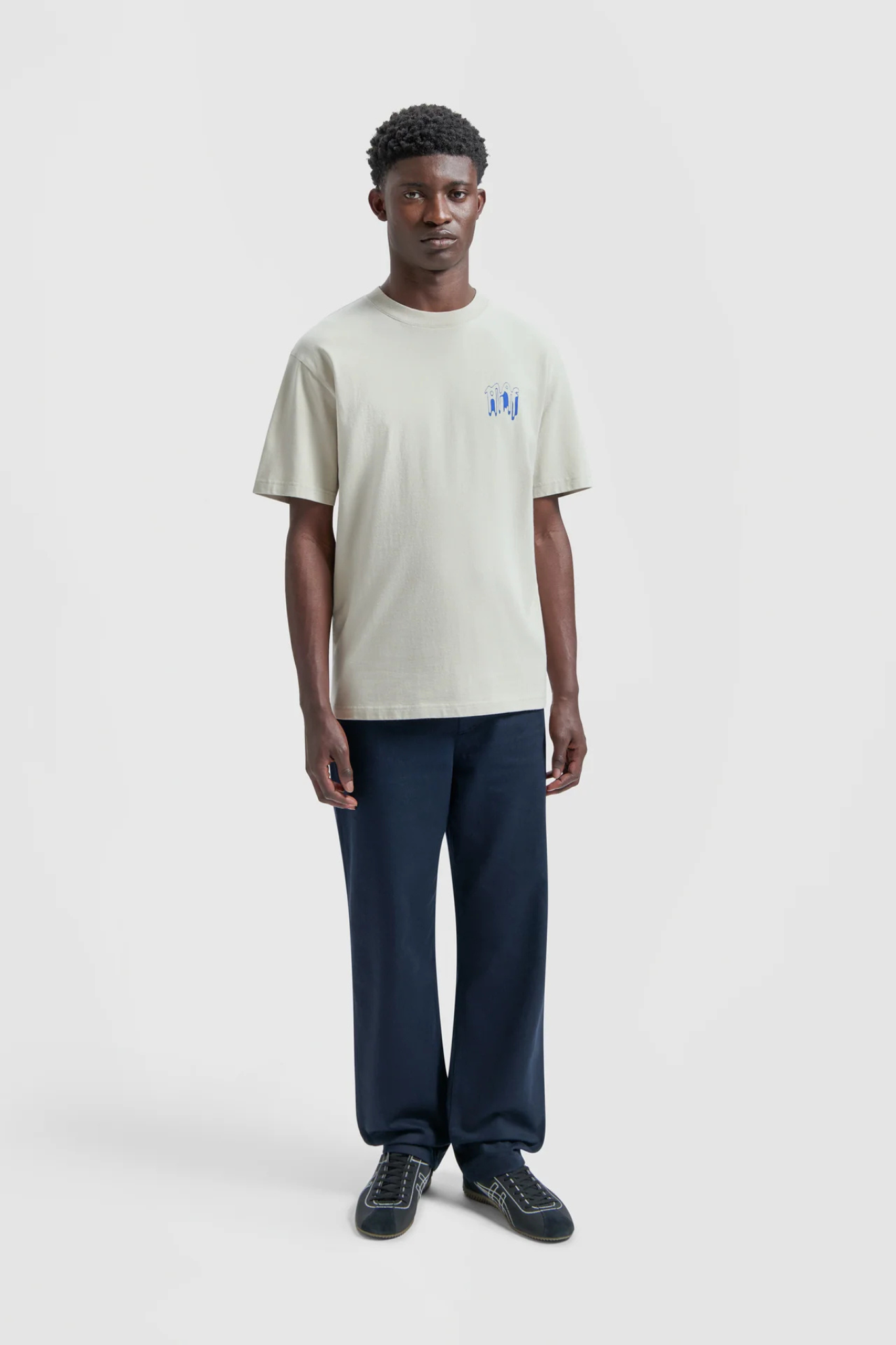 Model wearing the Olaf smudge logo t-shirt in beige and logo in blue. Front view