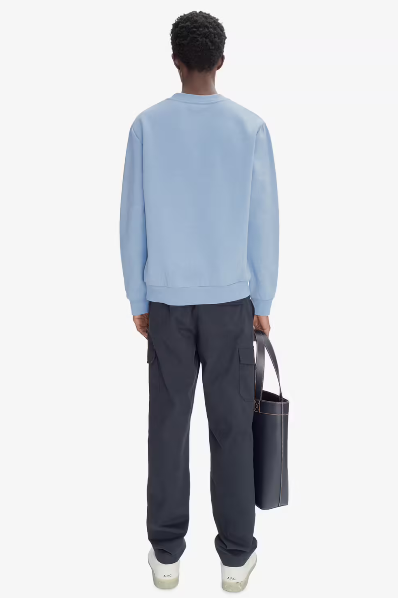 Model wearing the APC overdye sweatshirt in light blue with logo in ecru. Back view