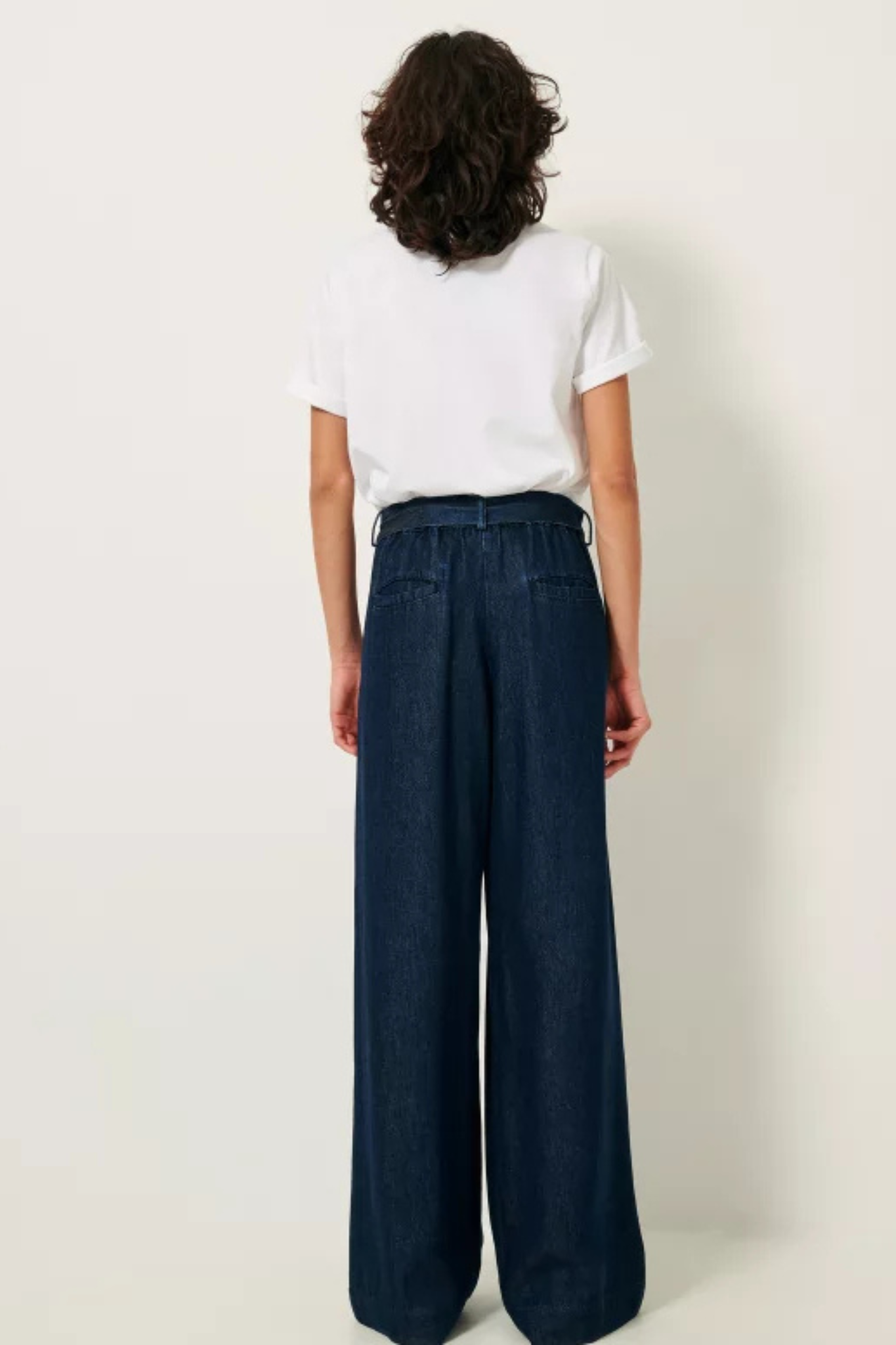 Model wearing the Sessun rinim elastic waisted pants in denim blue. Back view