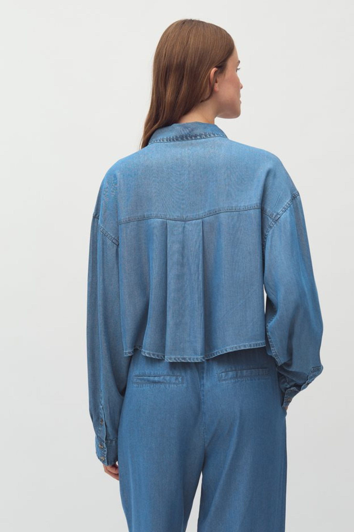 Model wearing the MBYM emele talvi shirt in mid vintage wash. Back view