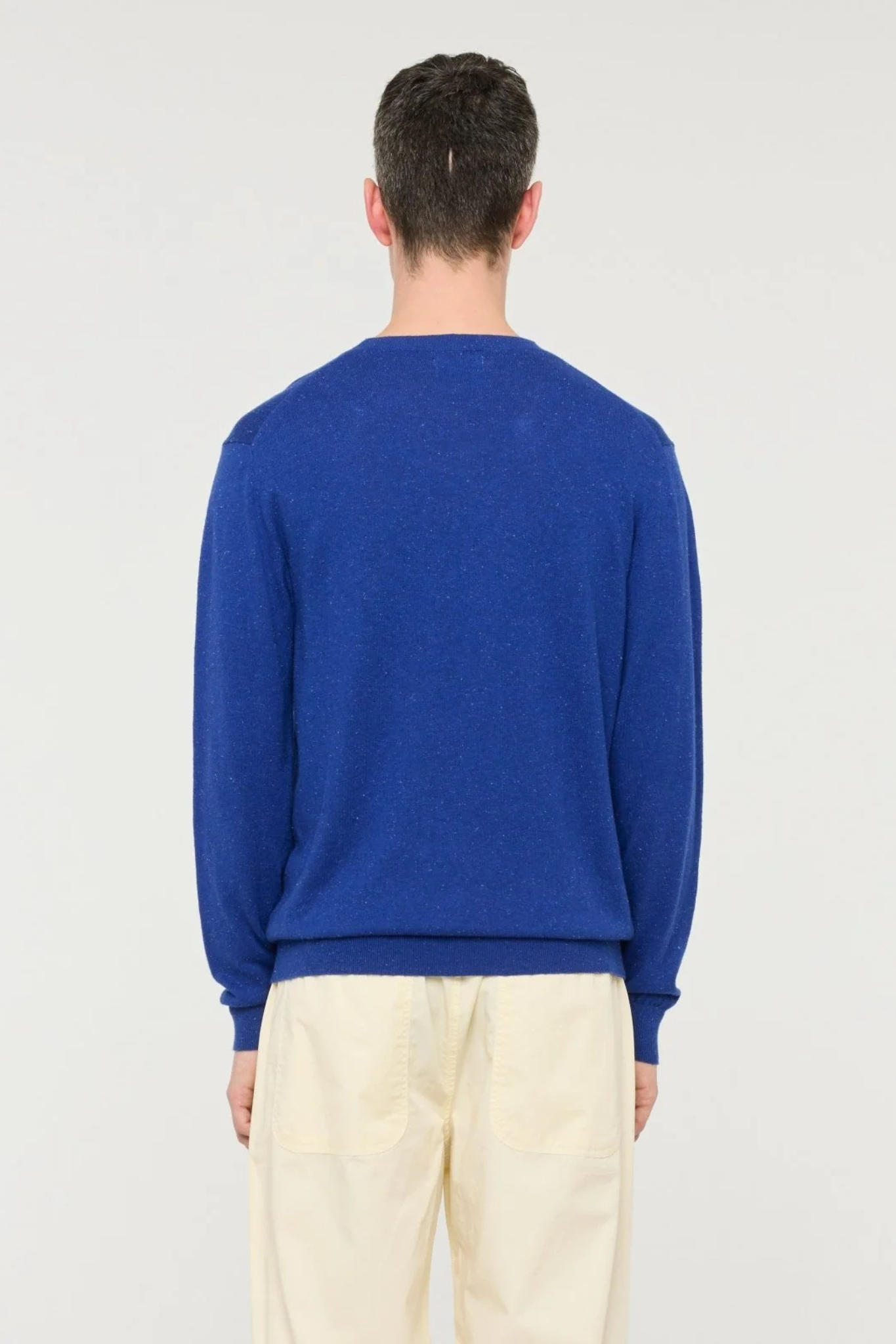 Model wearing the Castart eyeball sweater in blue cobalt. Back view