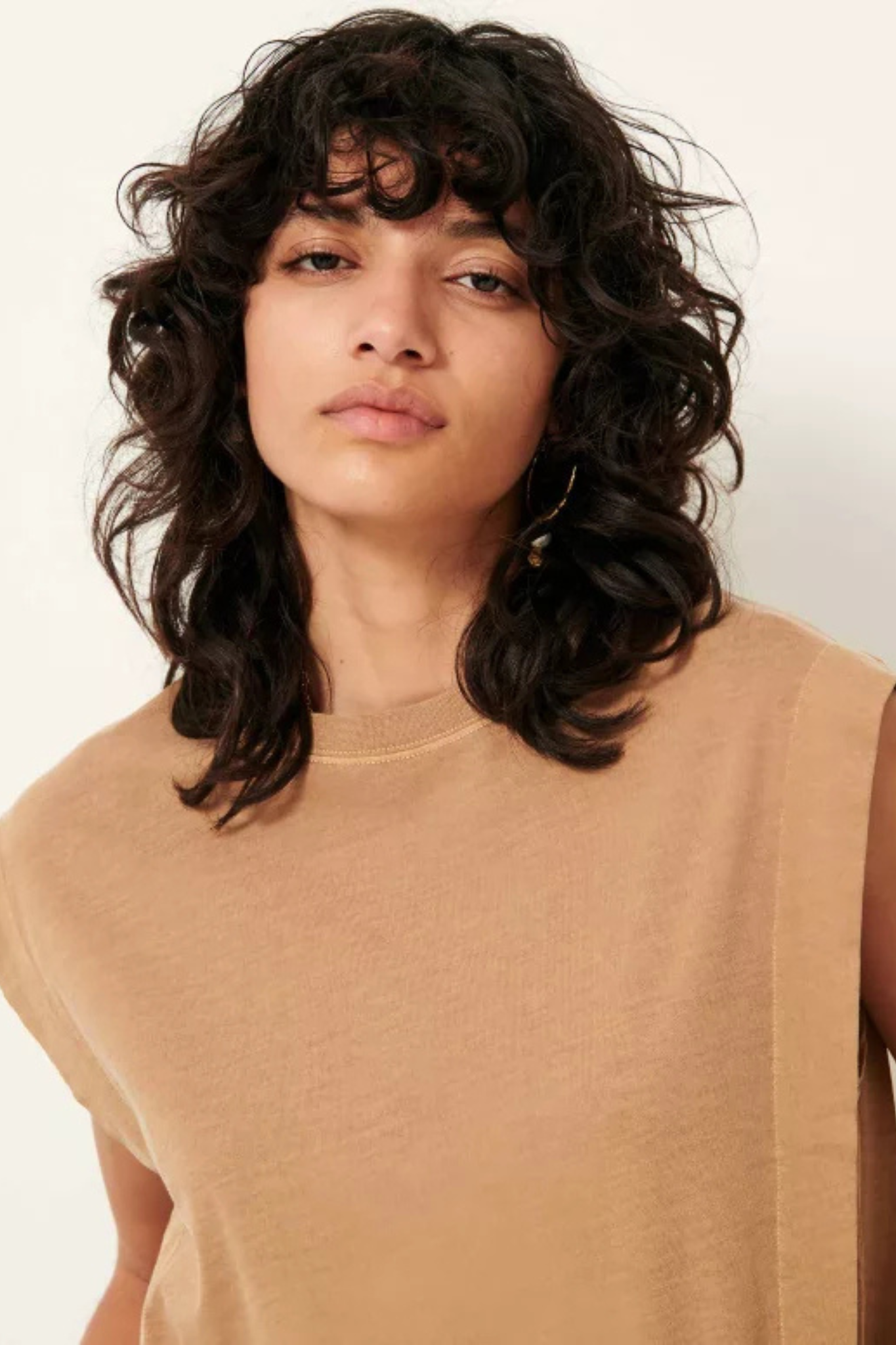 Model wearing the Sessun orlando pleated sleeveless t-shirt in camel. Close front view