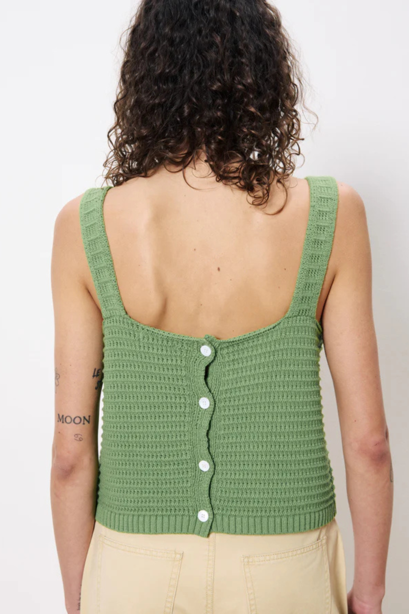 Model wearing the FRNCH celuta top in green. Back view