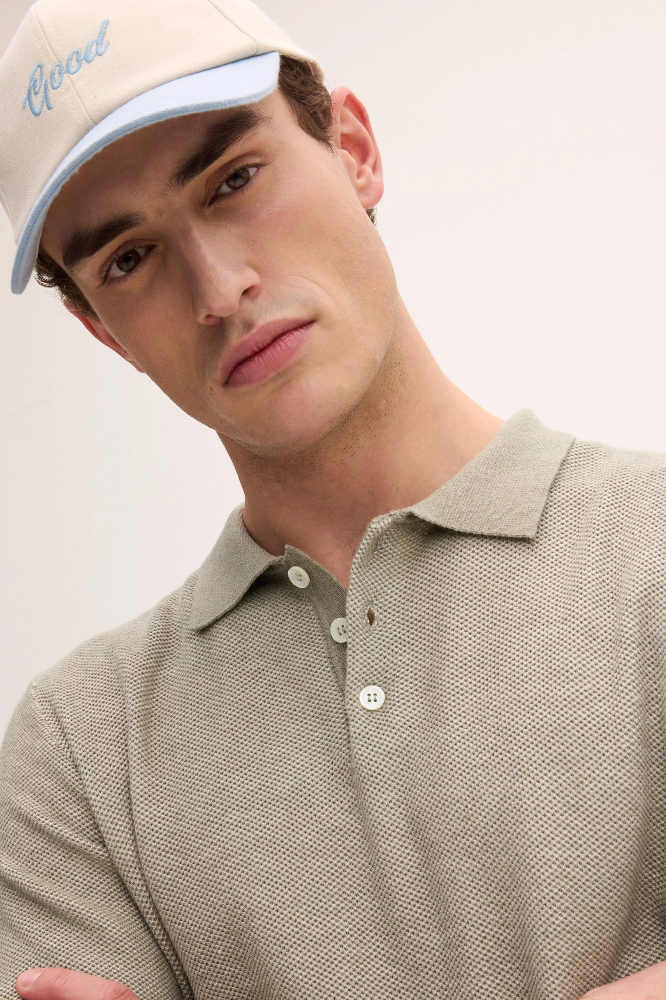 Model wearing the Goodpeople polo power shirt in green and white. Front view