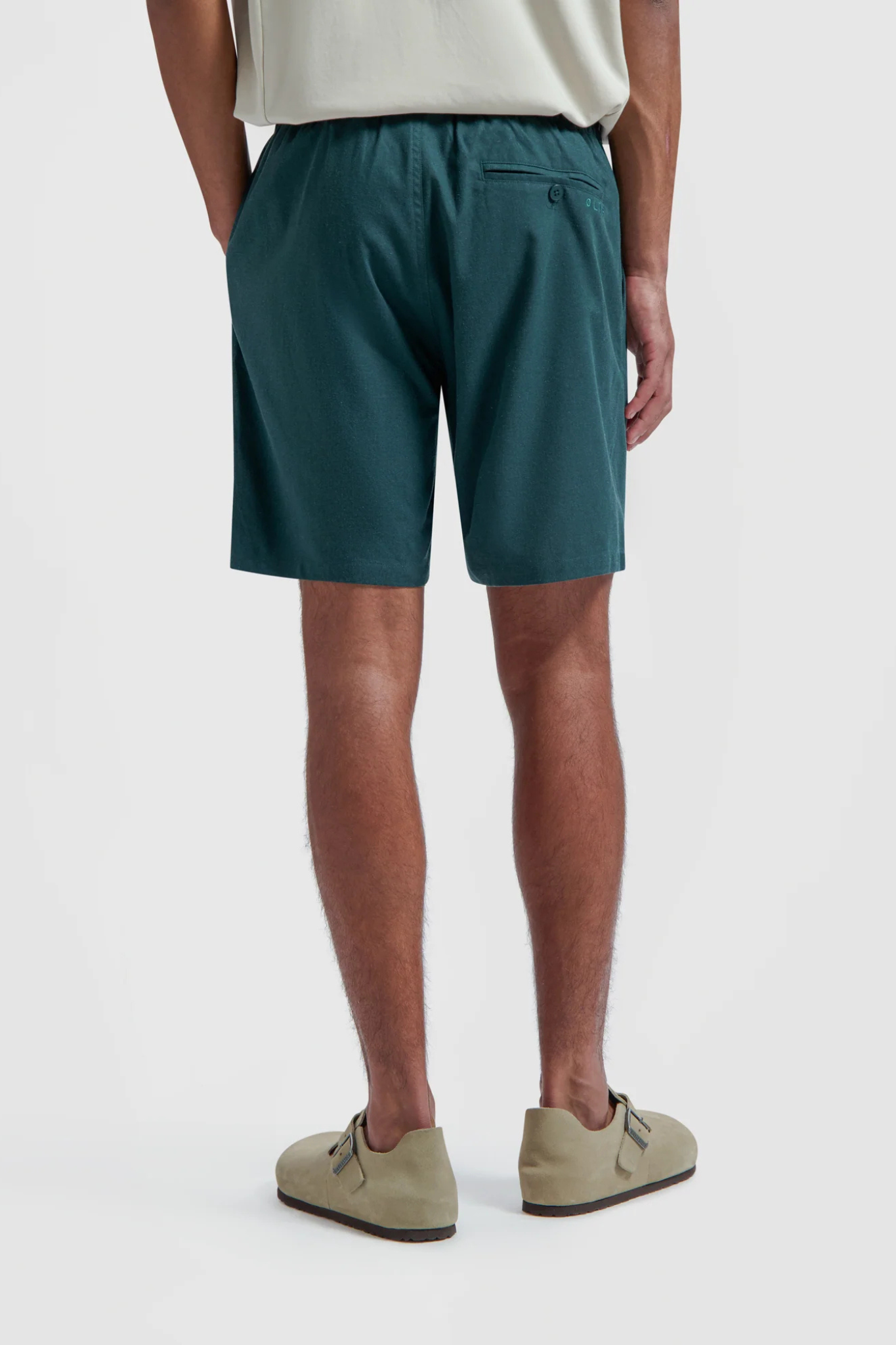 Model wearing the Olaf linen shorts in dark green. Back view