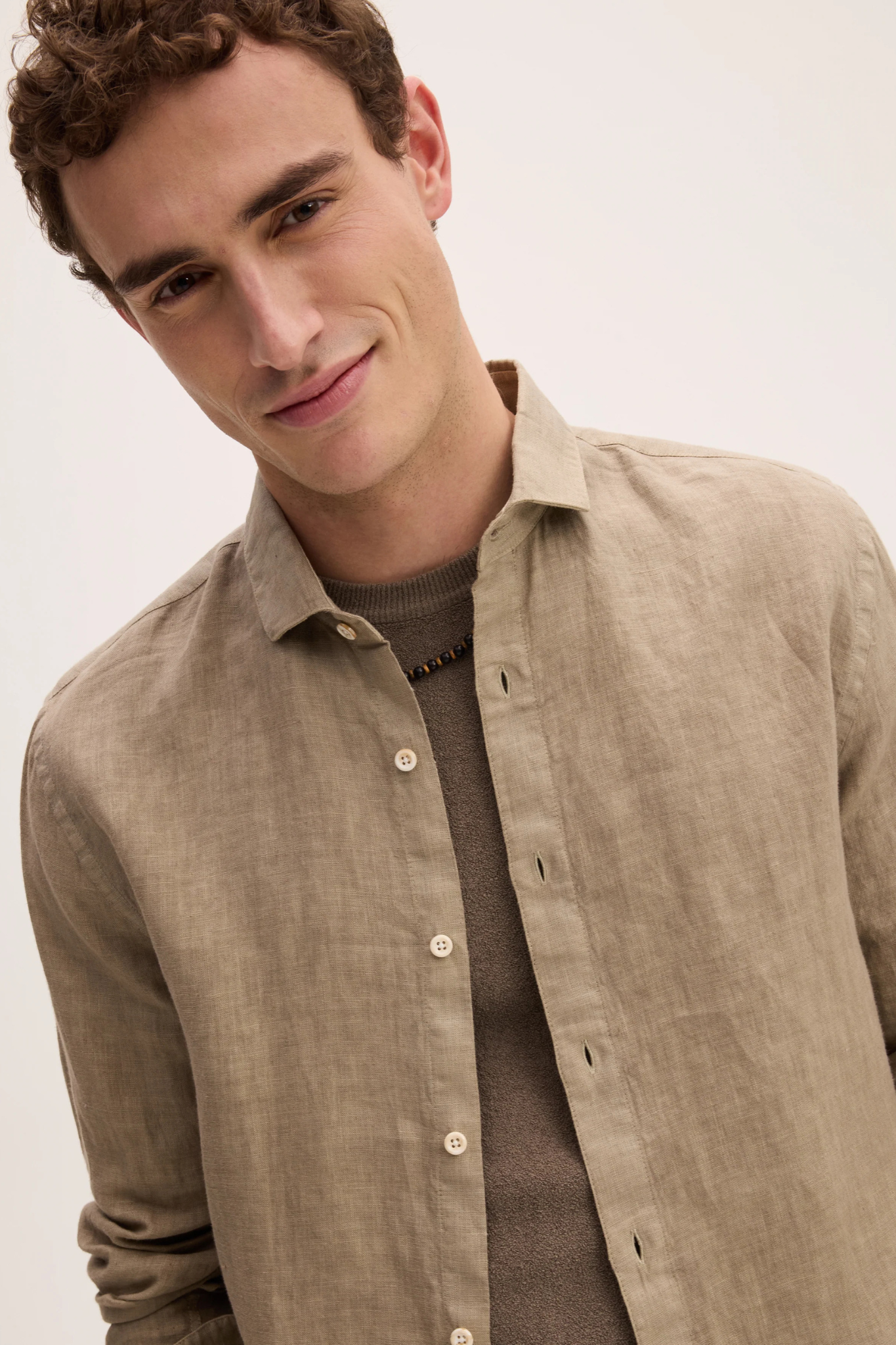 Model wearing the Goodpeople soho shirt in dark taupe. Close front view