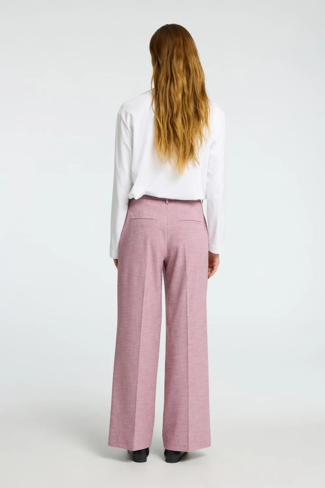 Model wearing the Selected Femme rae pants in bleached mauve/melange. Back view