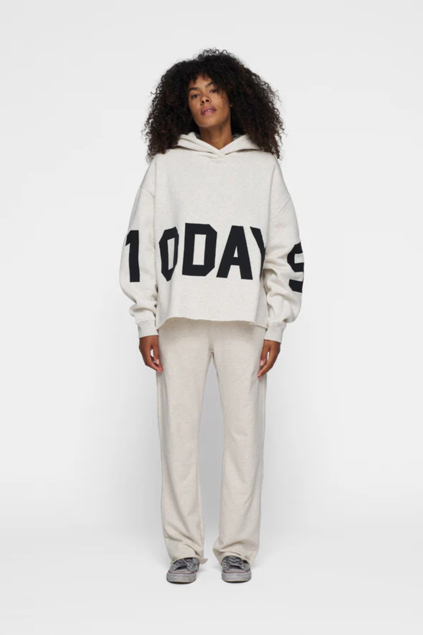 Model wearing the 10DAYS statement logo hoodie in soft white melee. Front view