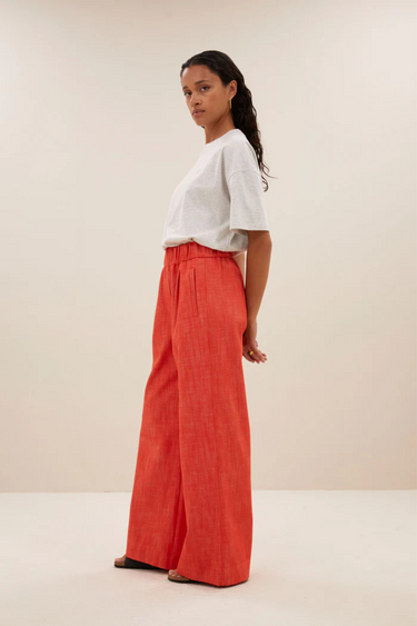 Model wearing the By-Bar Benji twill pants in poppy red. Side view