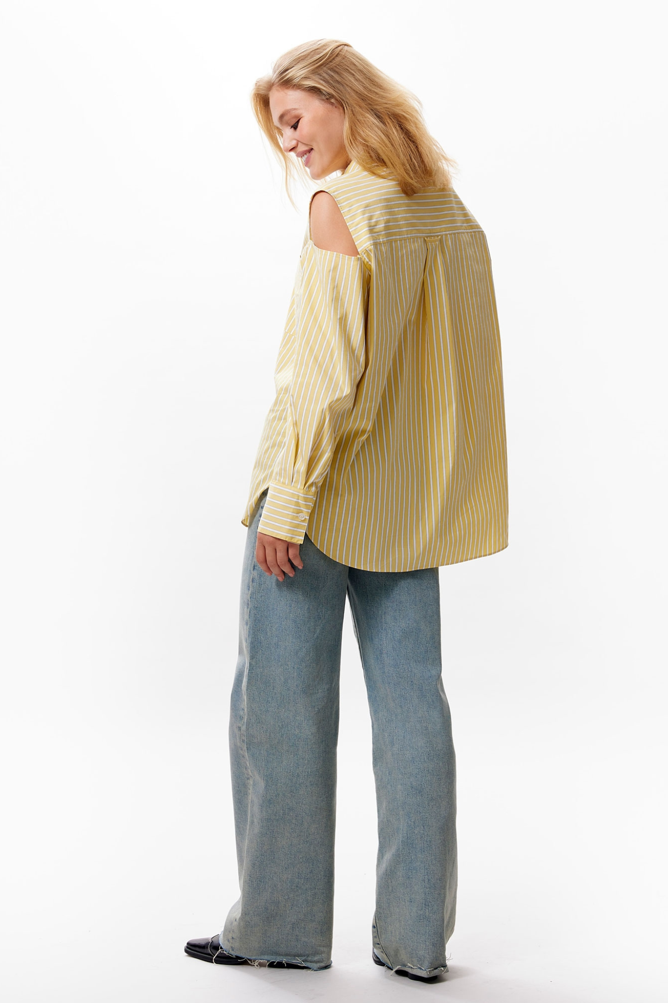 Model wearing the Catwalk Junkie open shoulder blouse in yellow. Side view