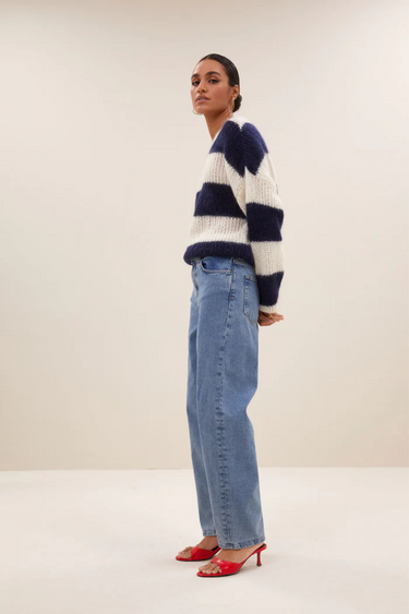 Model wearing the By-Bar Evi striped pullover in white and blue. Side view