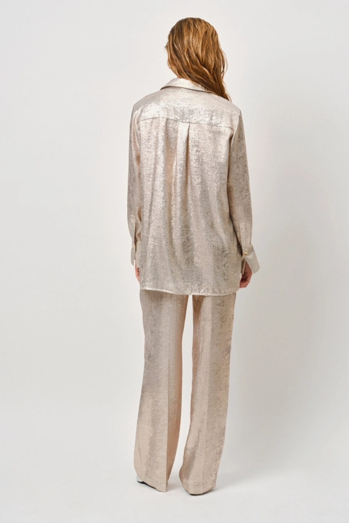 Model wearing the Dante6 Charm metallic pants in champagne. Back view