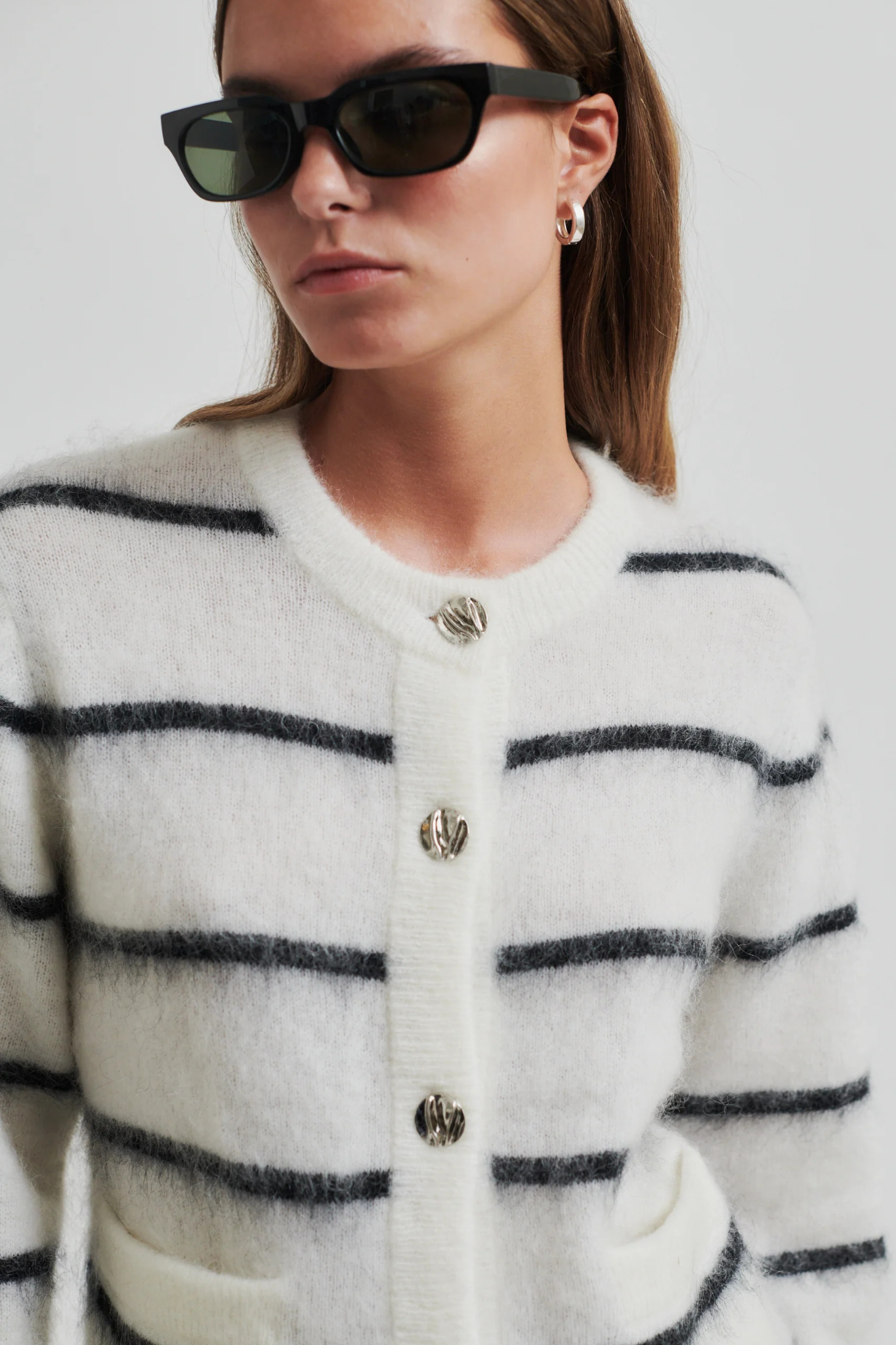 Model wearing the Second Female ovalina knit cardigan in striped white and black. Close front view