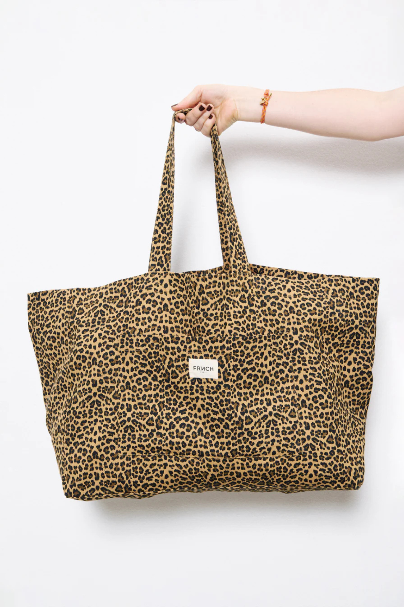 Model wearing the FRNCH vida bag in leopard. Front view