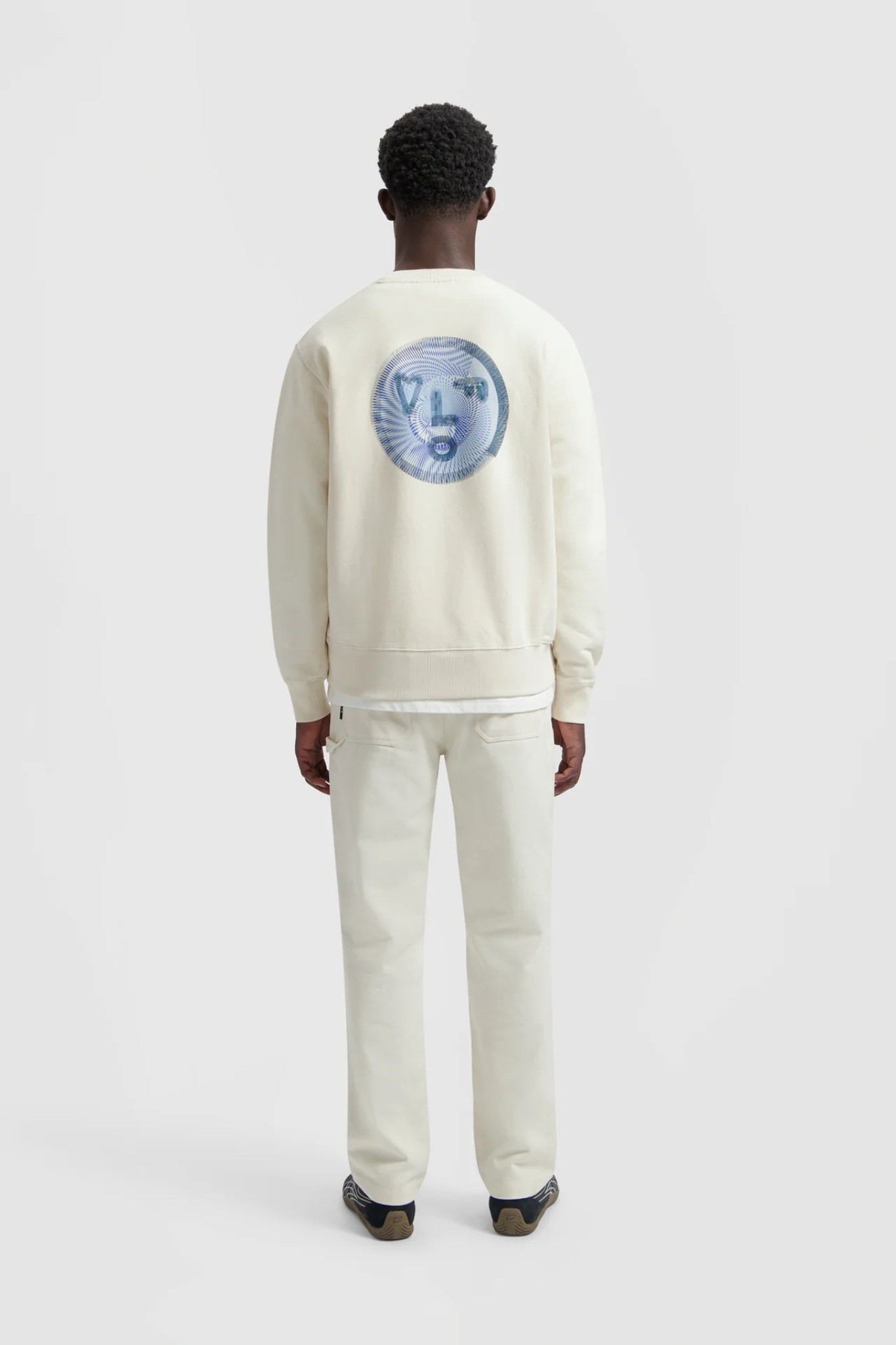 Model wearing the Olaf spiral face crewneck sweater in white and face in blue. Back view