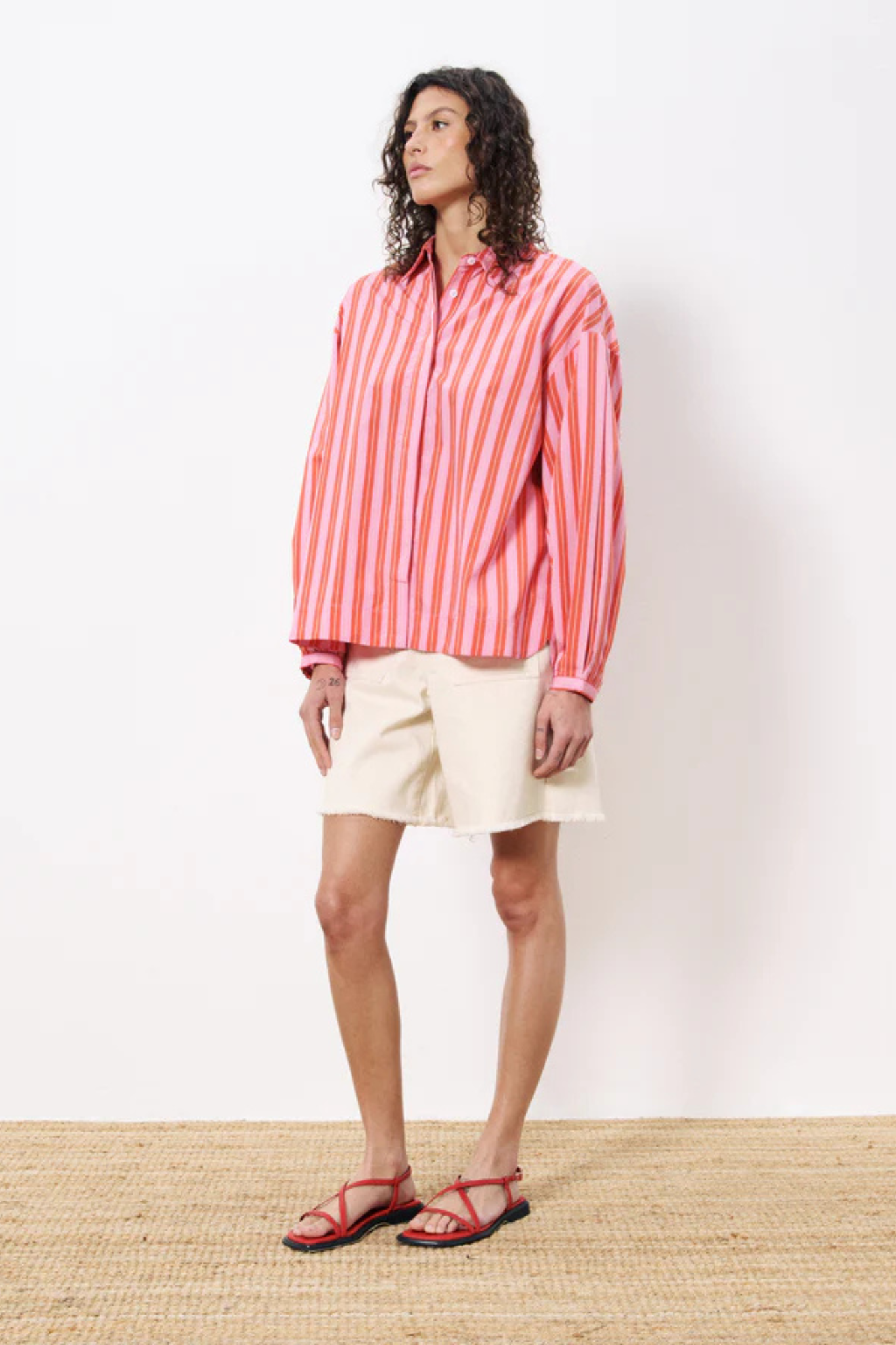 Model wearing the FRNCH catheline shirt in pink and orange striped. Front view