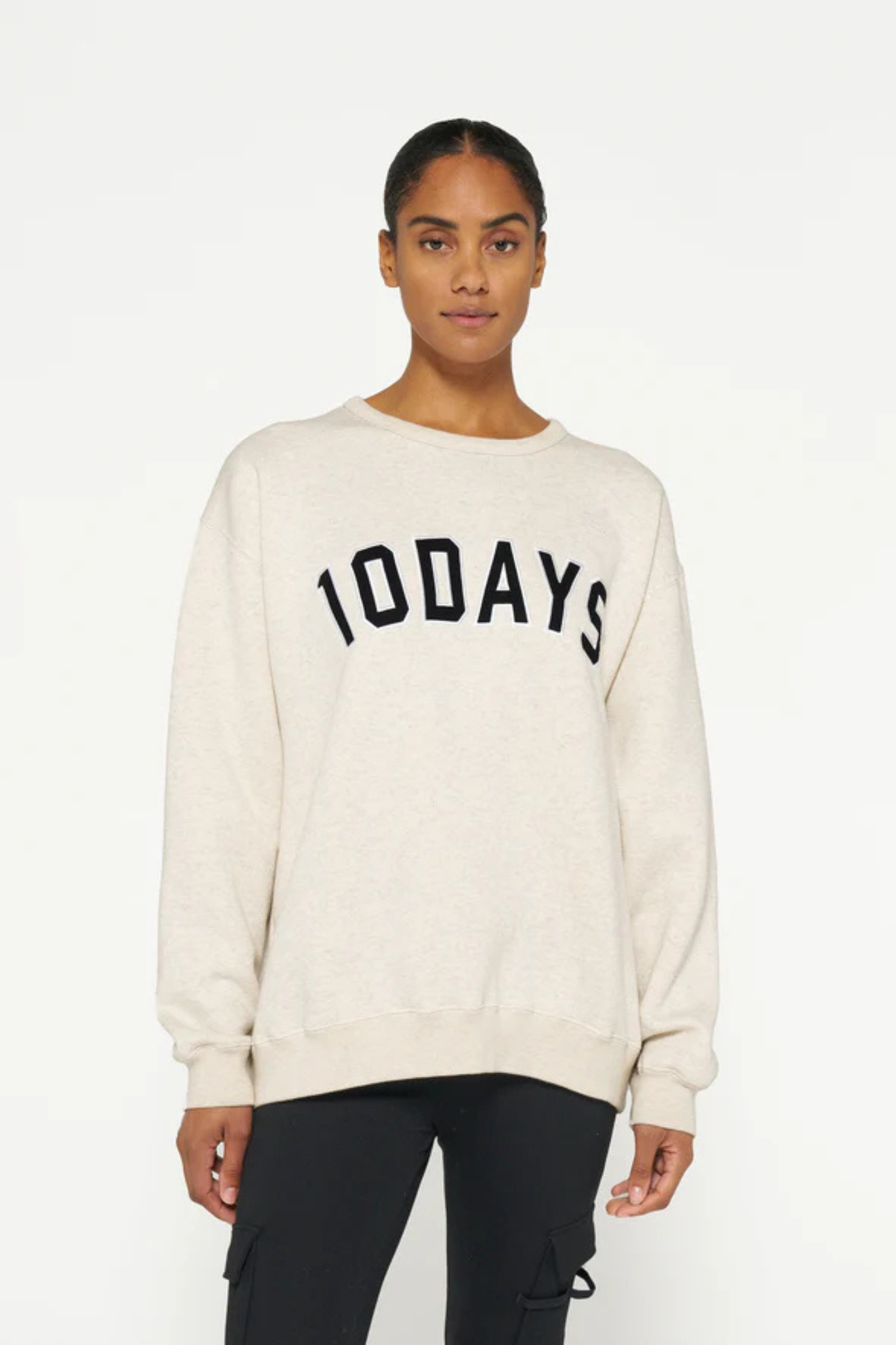 Model wearing the 10DAYS statement sweater in soft white melee. Front view