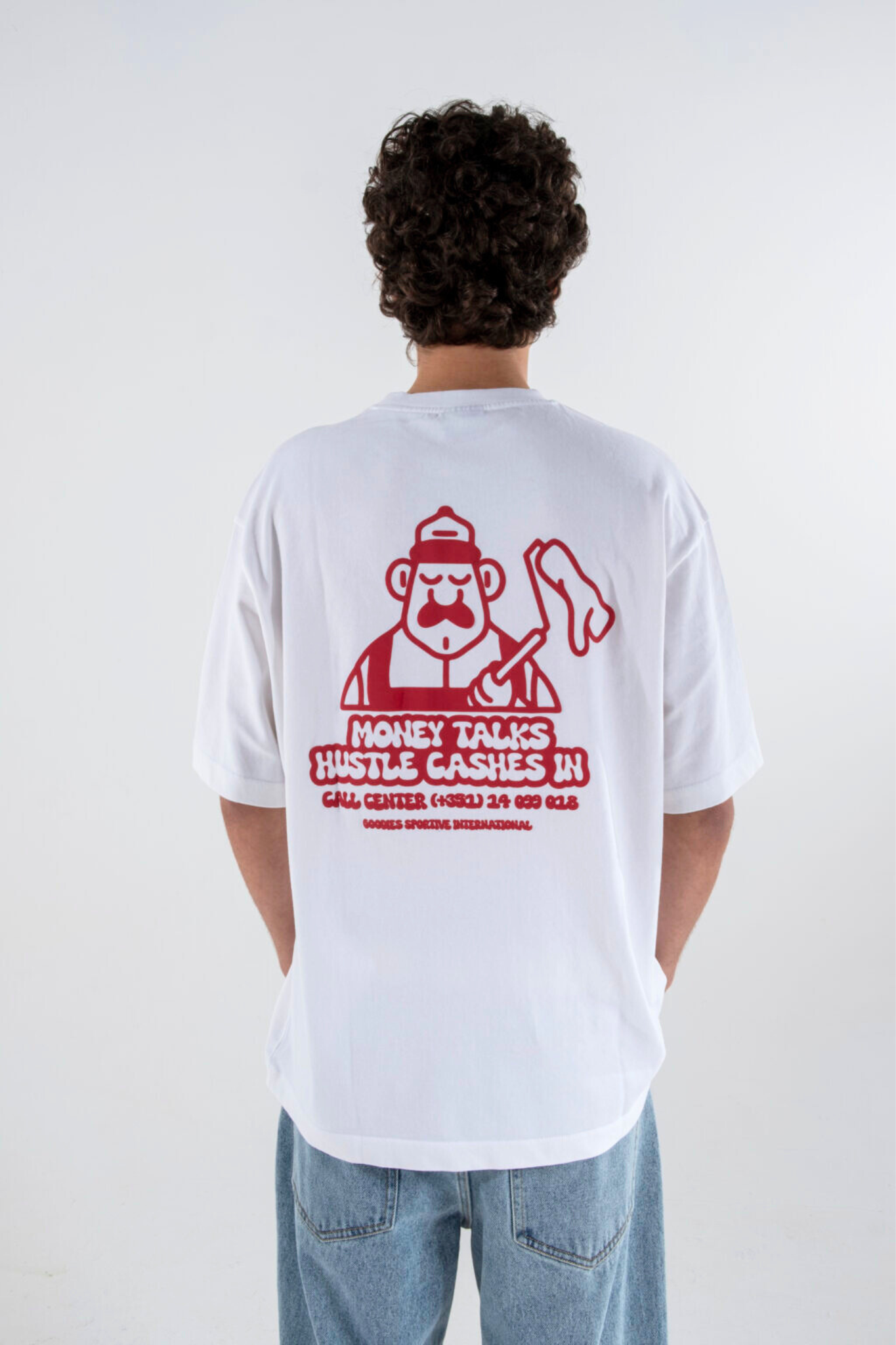 Model wearing the Goodies Sportive money talks t-shirt in white and graphic in red. Back view