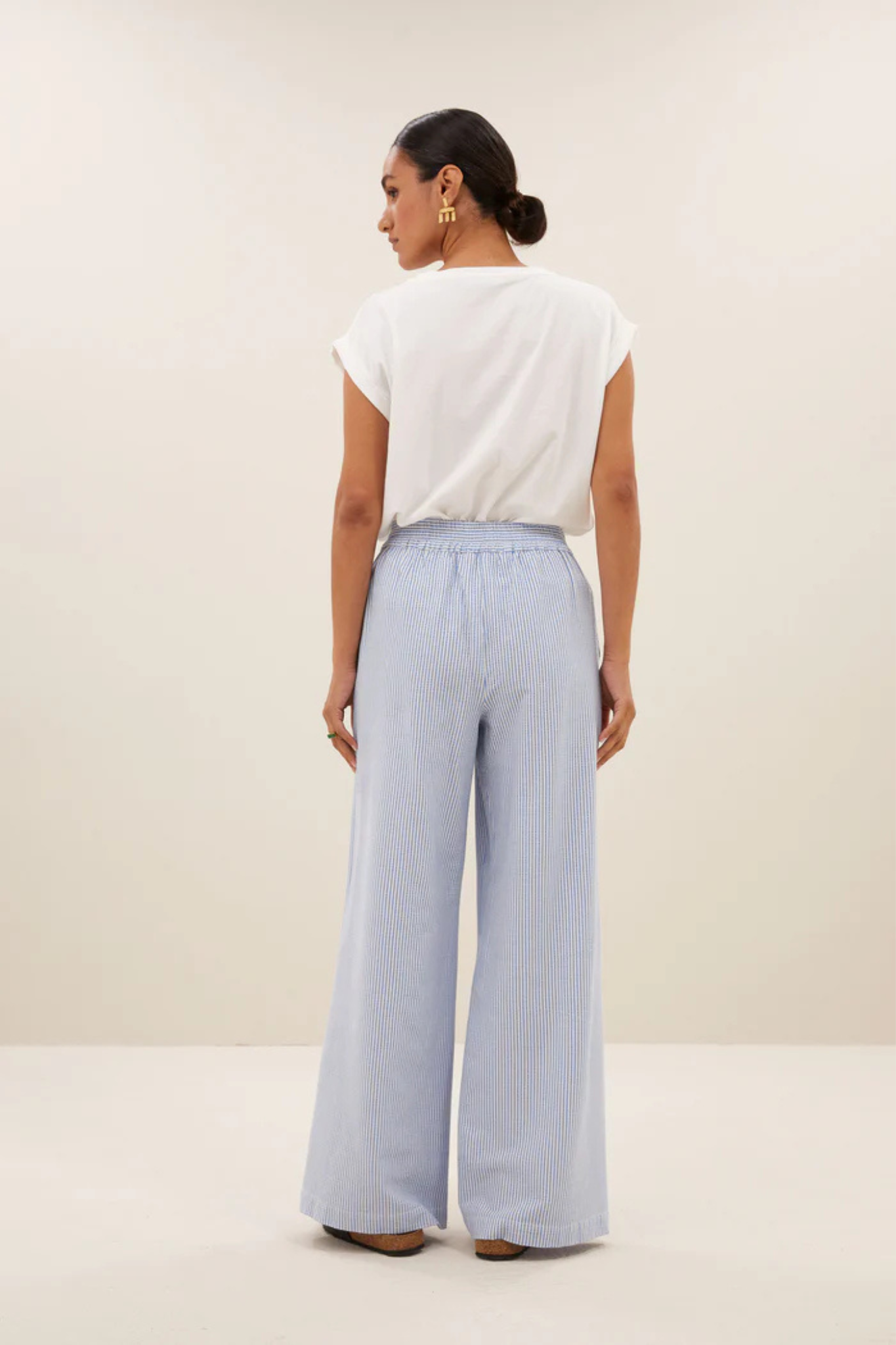 Model wearing the By-Bar randy stripe pants in blue seer stripe. Back view