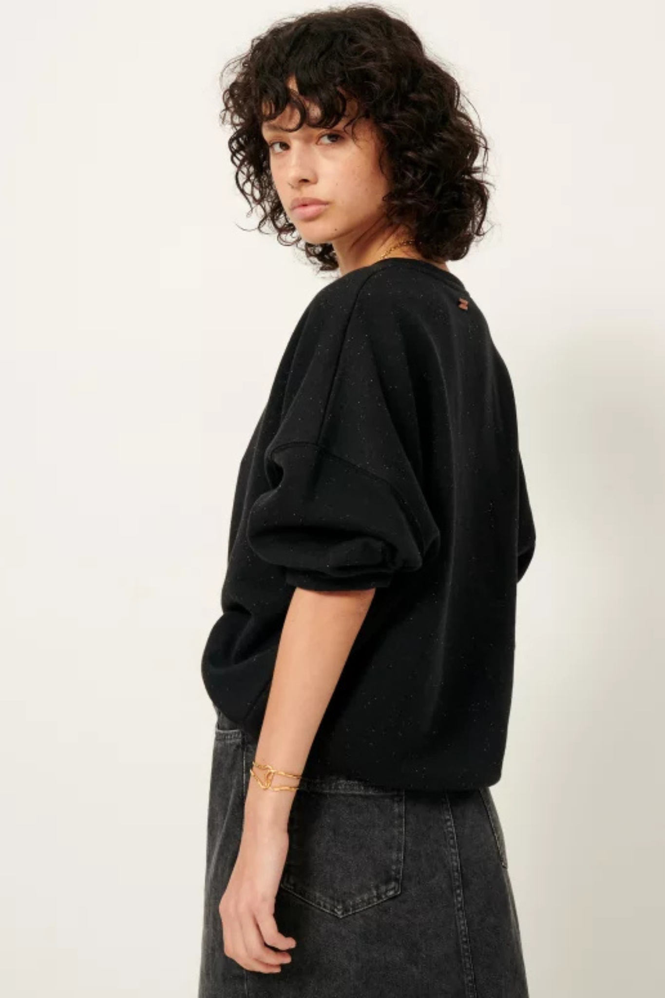 Model wearing the Sessun chebbi sweat oversized in black. Side view