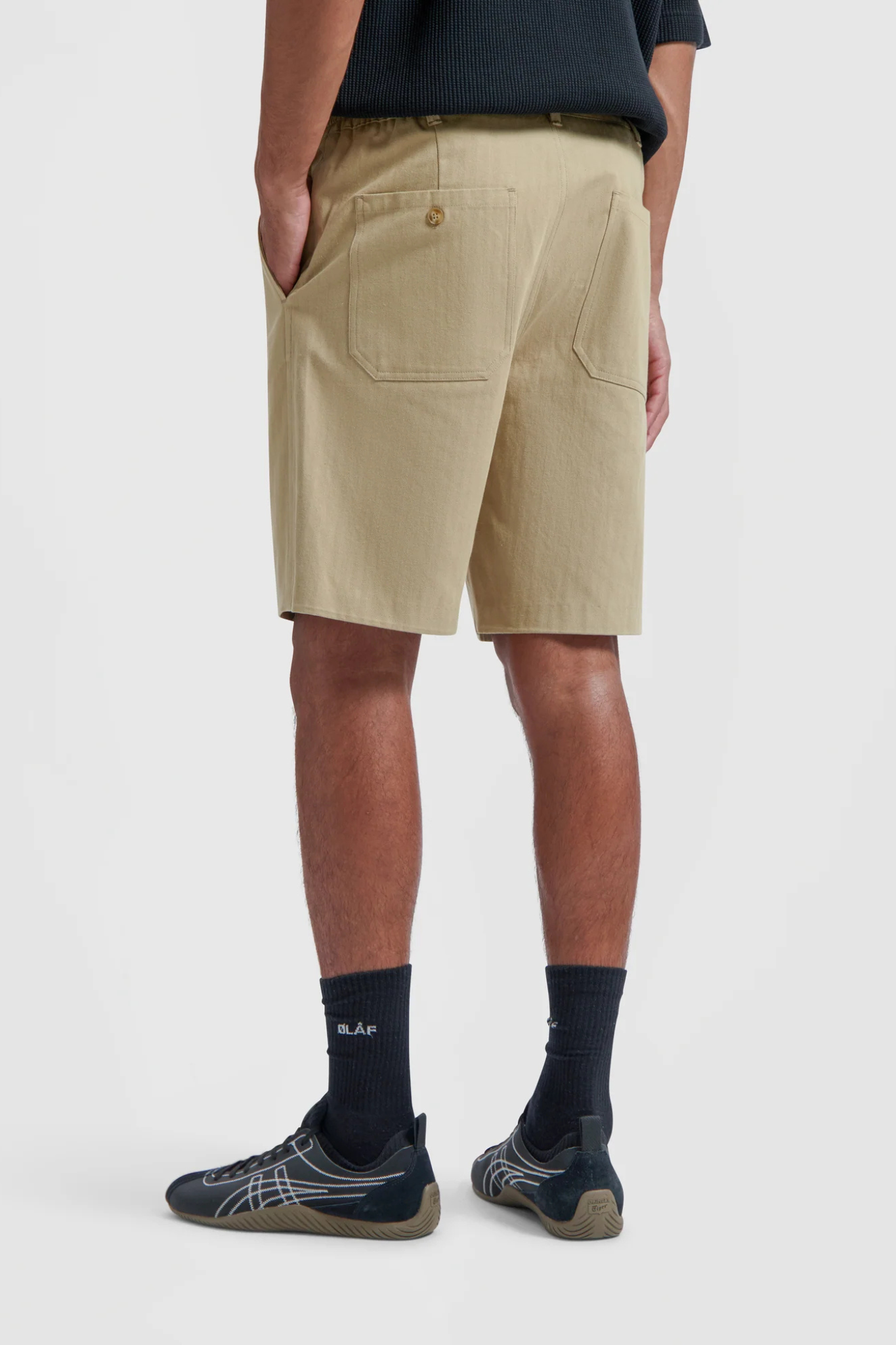 Model wearing the Olaf utility workwear shorts in beige khaki. Back view