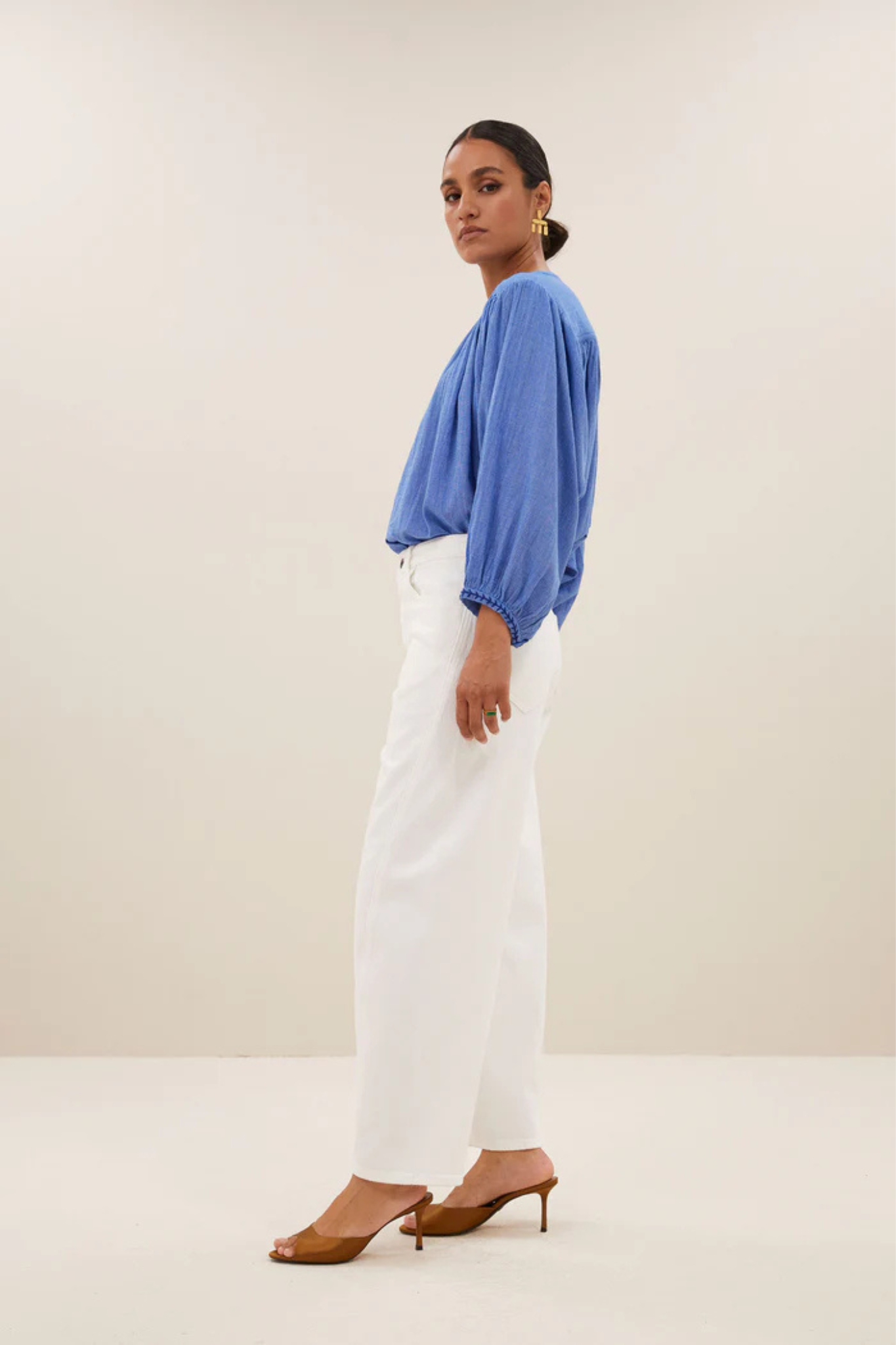 Model wearing the By-Bar becky athia blouse in sapphire blue. Side view