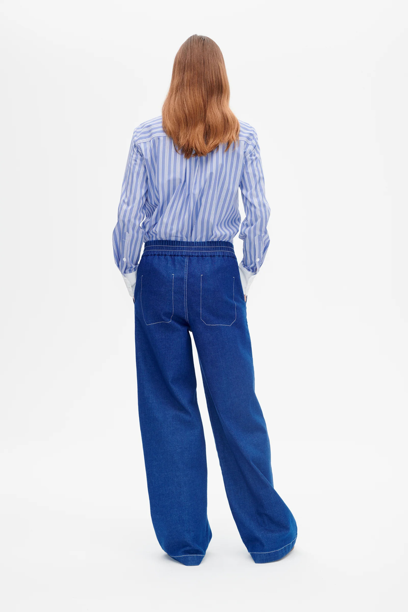 Model wearing the Baum Und Pferdgarten noiella jeans in blue. Back view