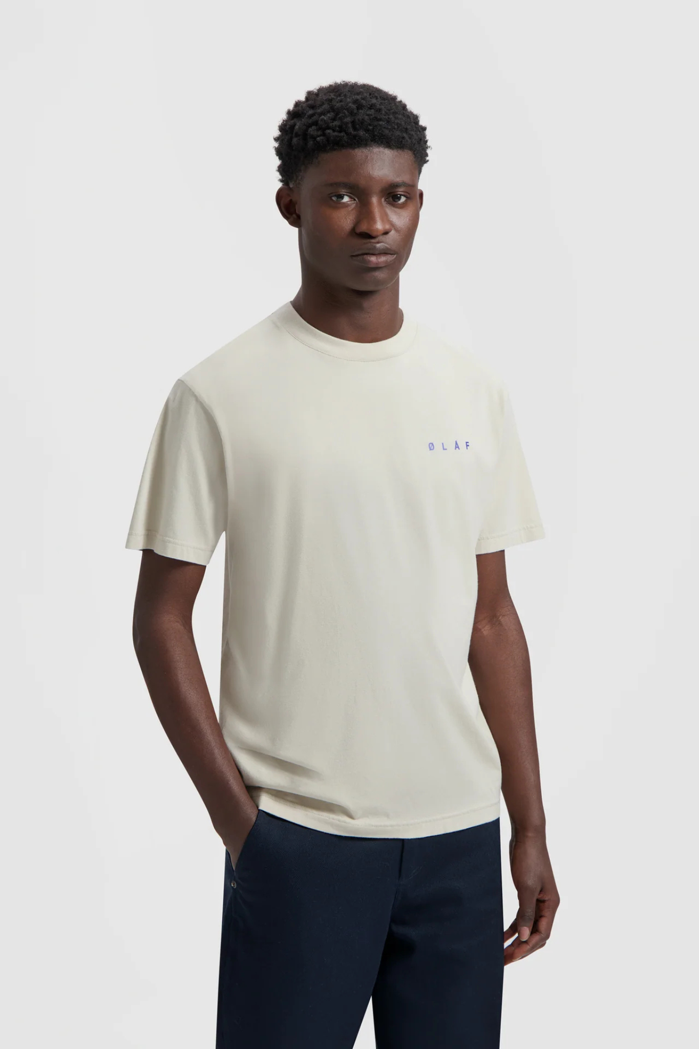 Model wearing the Olaf spiral face t-shirt in beige and face in blue. Front view