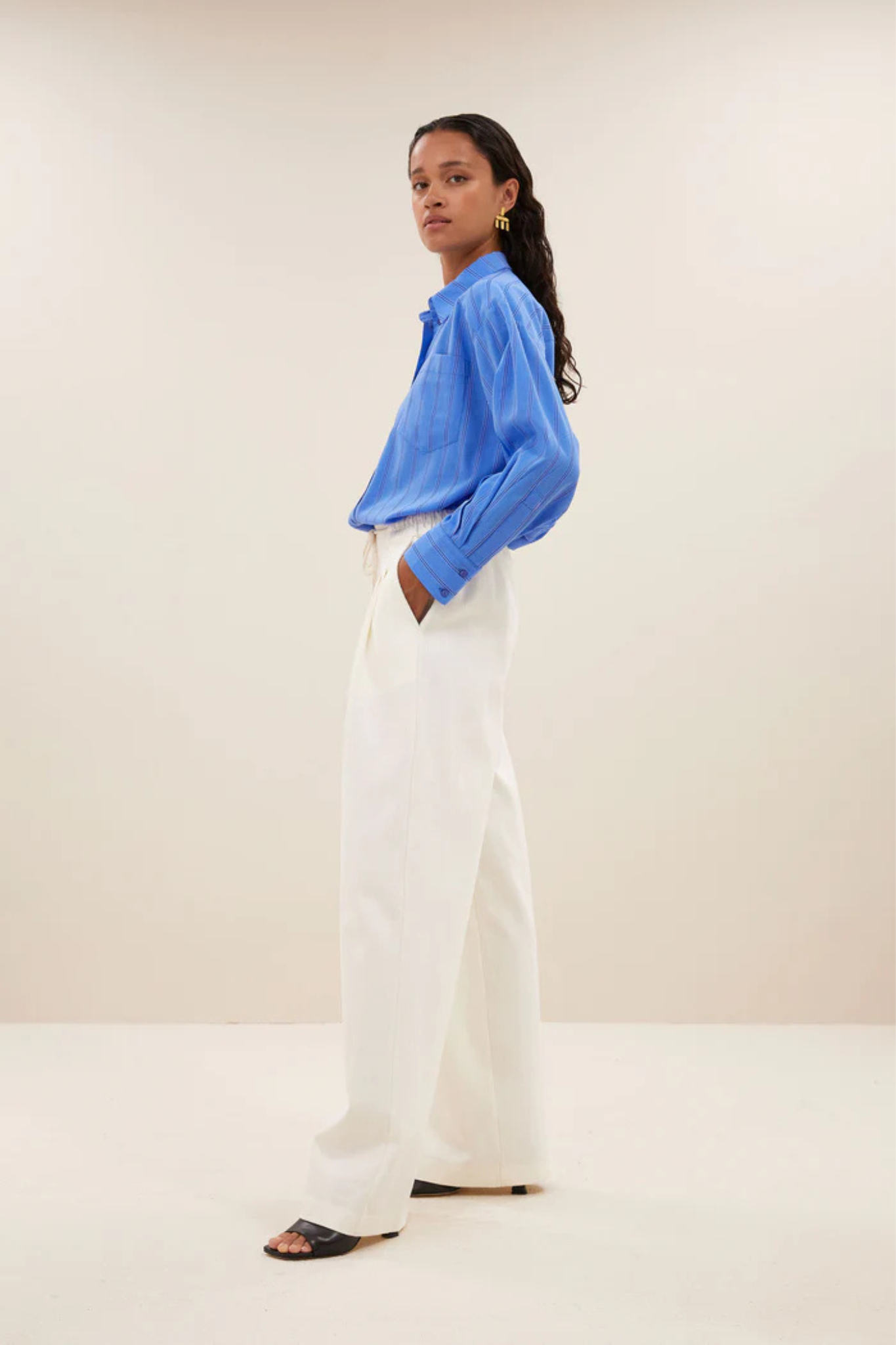 Model wearing the By-Bar nima stripe blouse in blue. Side view