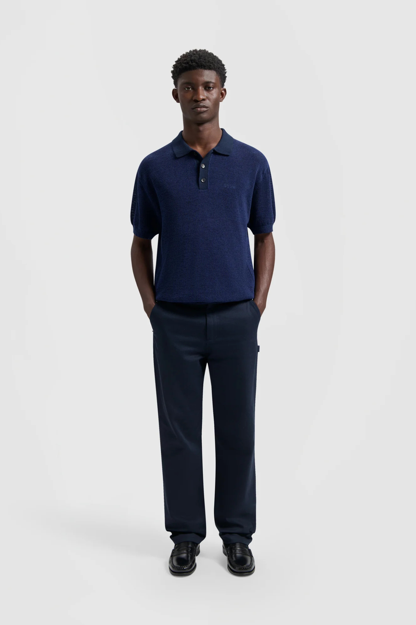 Model wearing the Olaf polo knit in dark navy. Front view