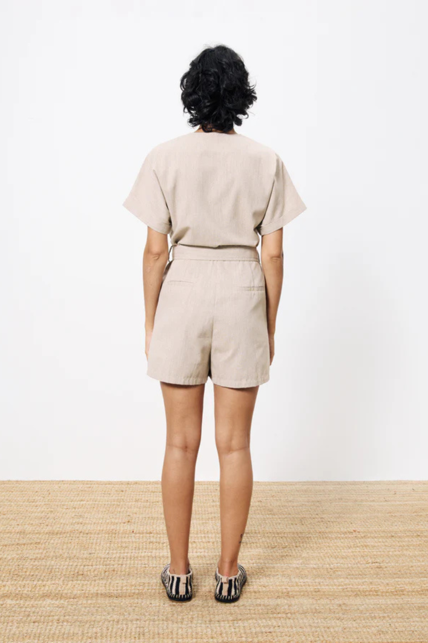 Model wearing the FRNCH adila combishort in beige. Back view