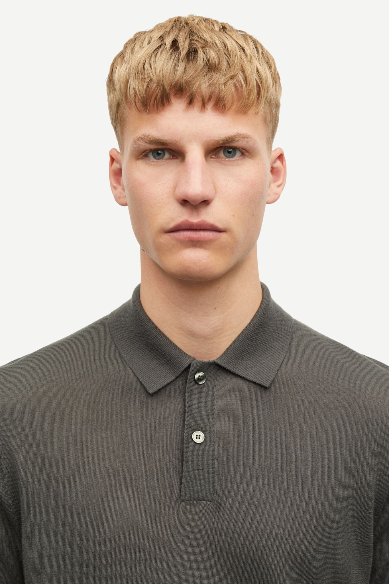 Model wearing the Samsoe Samsoe sarowan knit polo in grey. Front view