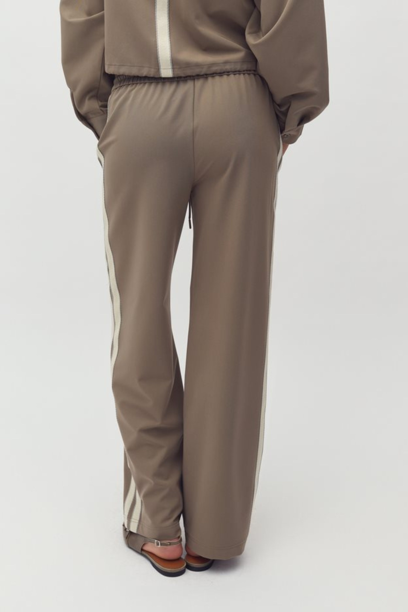 Model wearing the Mbym livigno franky pants in sand. Back view