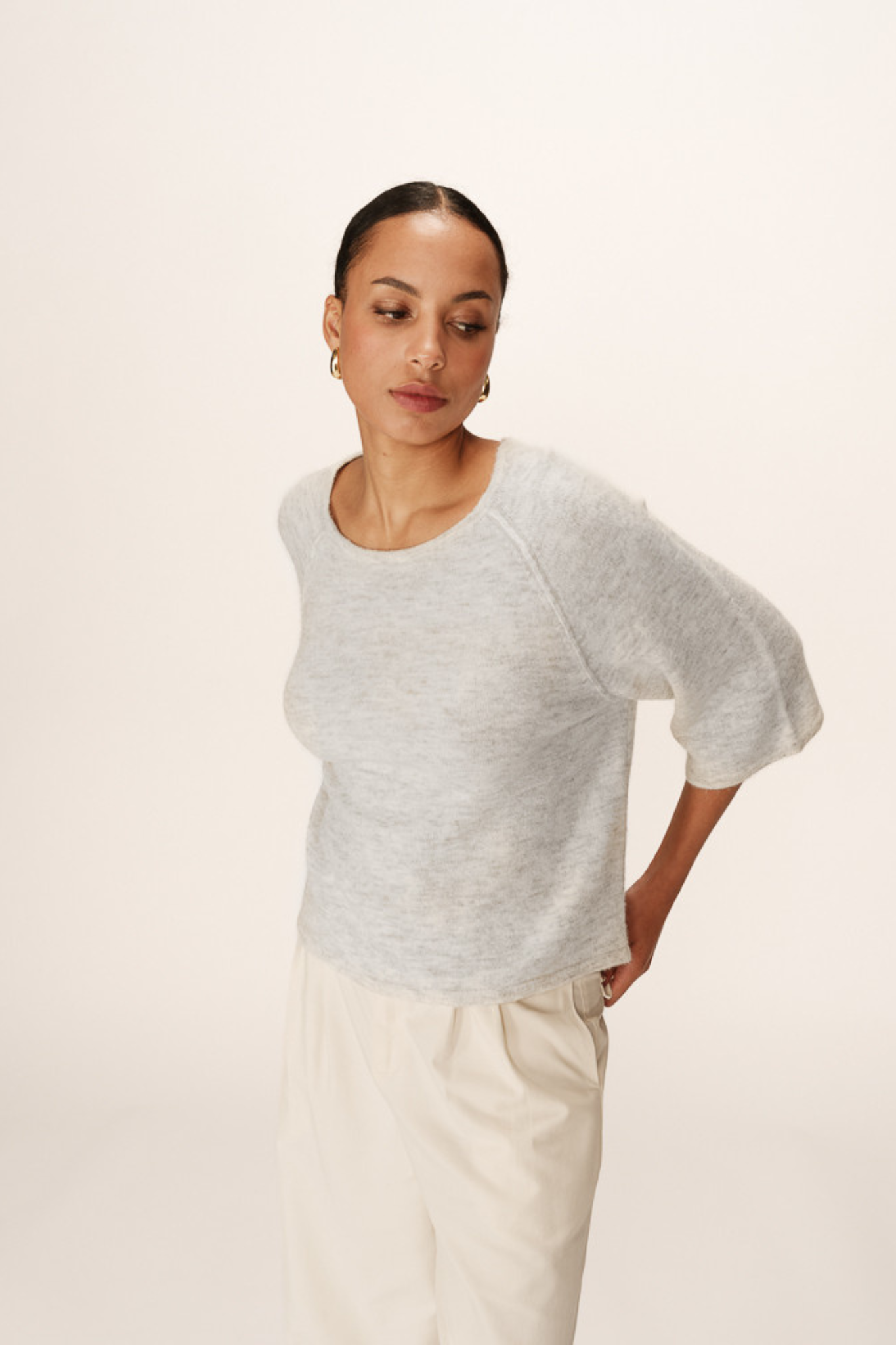 Model wearing the Grace & Mila paco sweater in grey. Front view