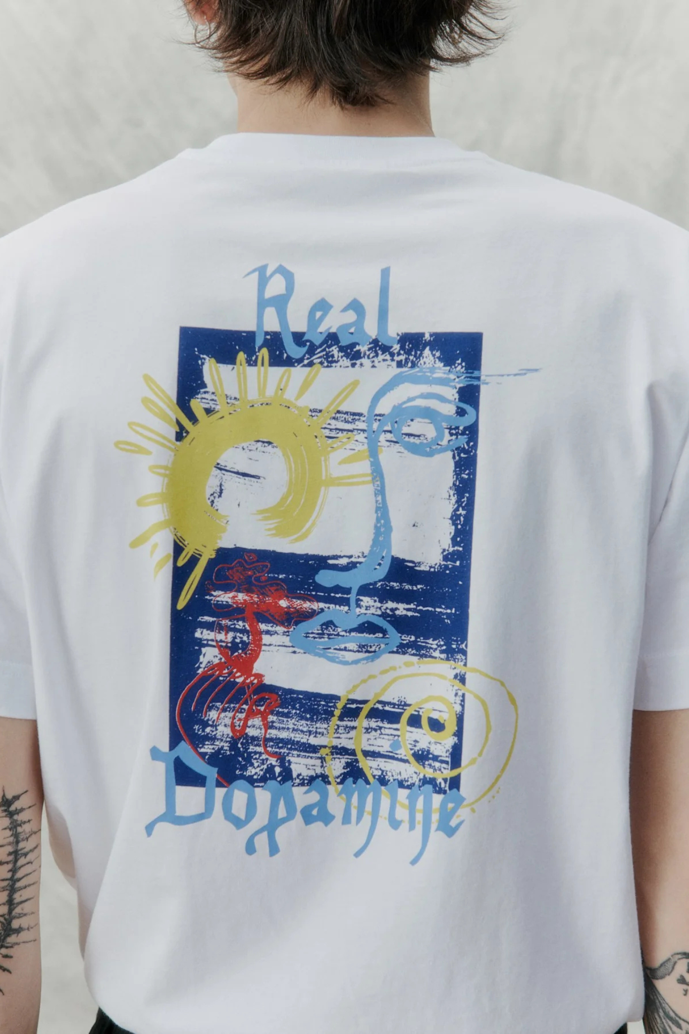 Model wearing the Libertine Libertine beat dopamine t-shirt in white. Back graphic view