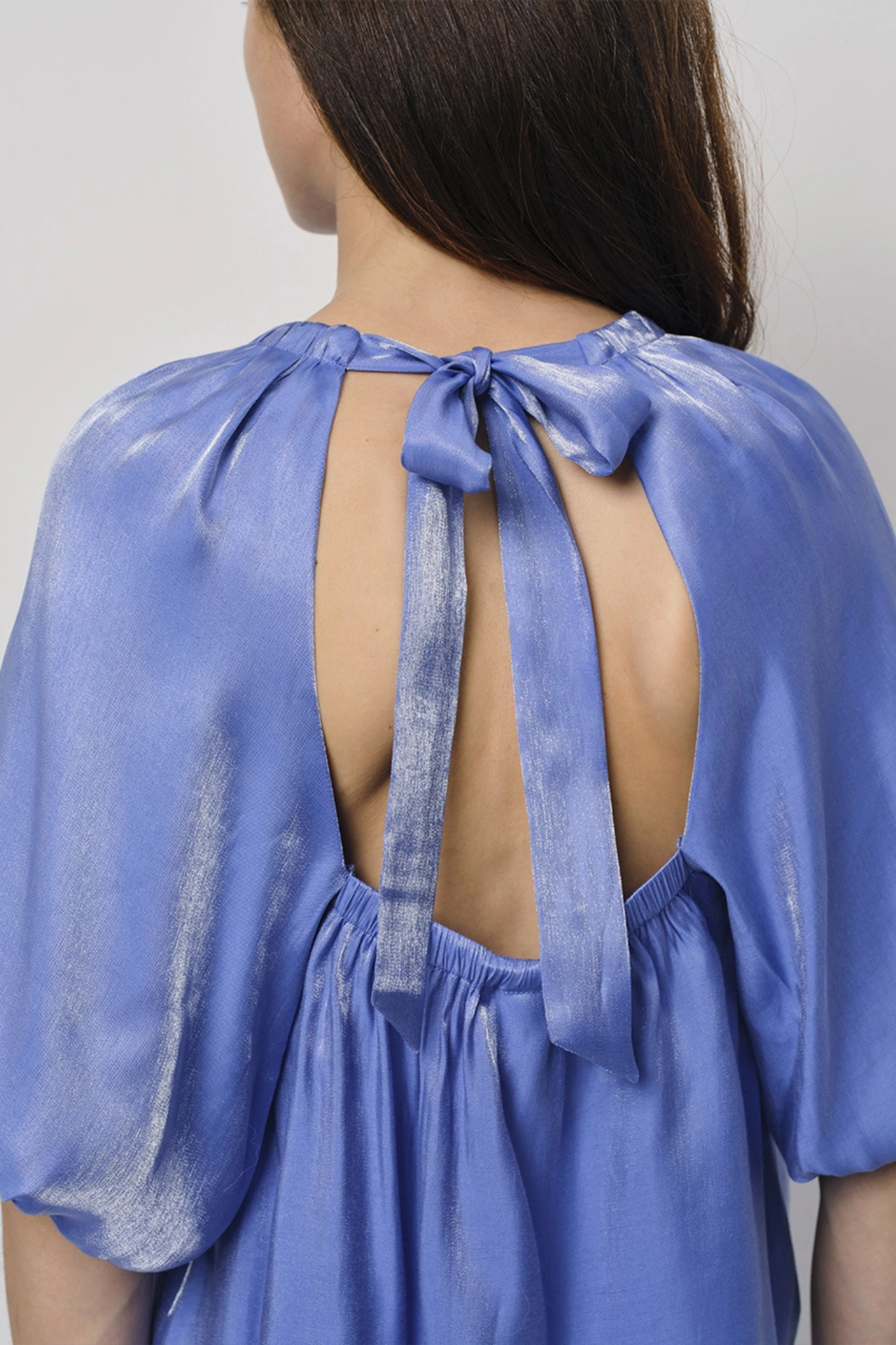 Model wearing the Dante6 simo shimmer back detail top in blue. Back view