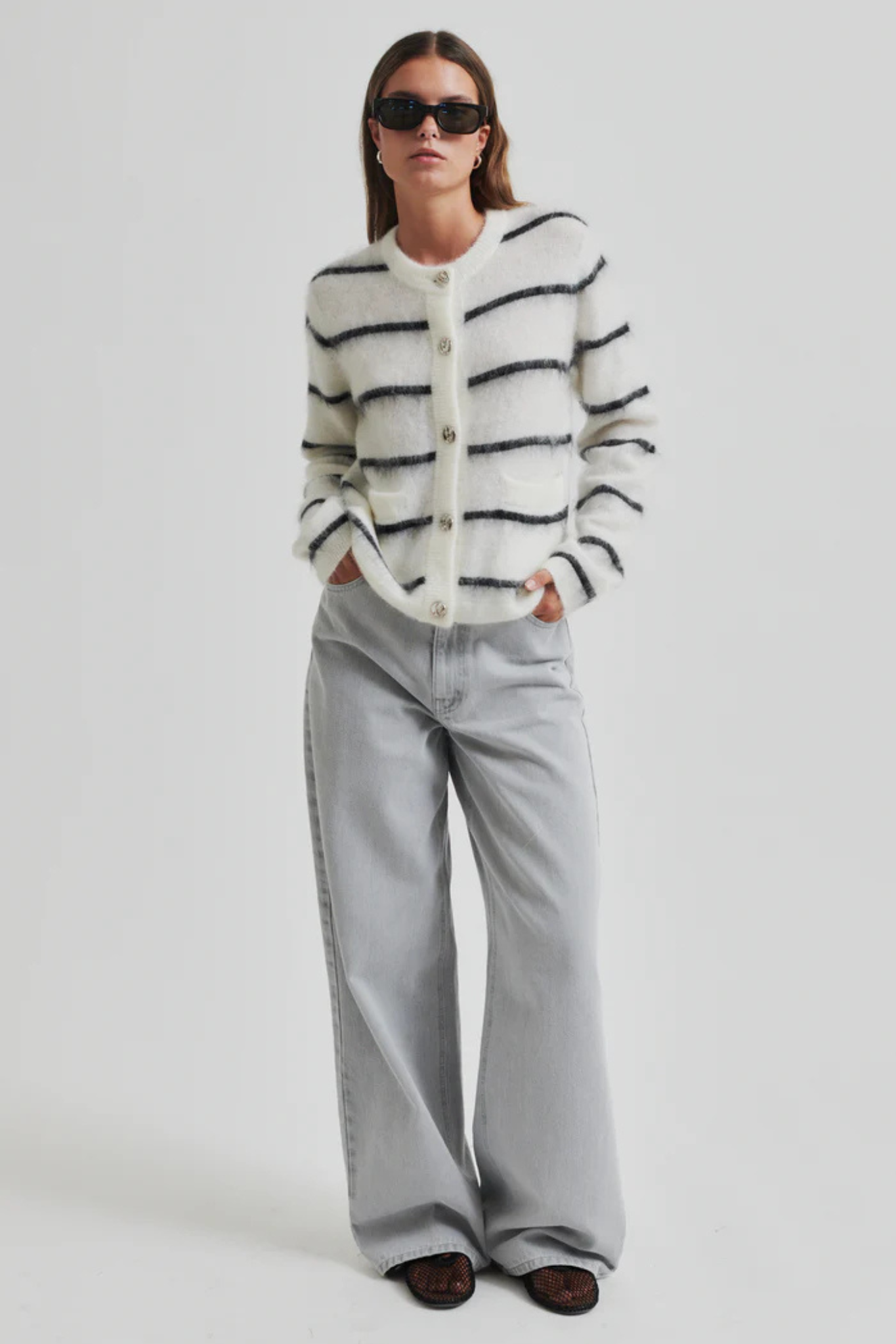 Model wearing the Second Female ovalina knit cardigan in striped white and black. Front view