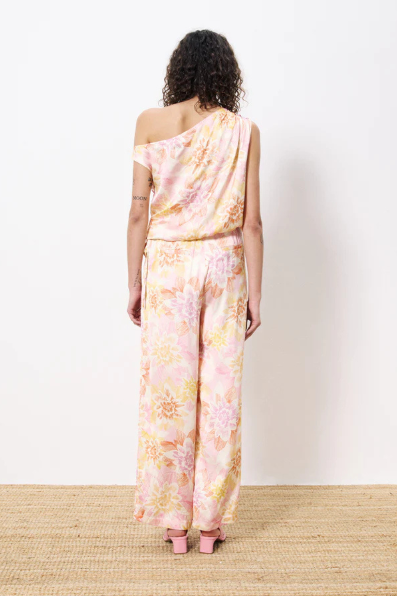 Model wearing the FRNCH philo pants in flower pattern. Back view