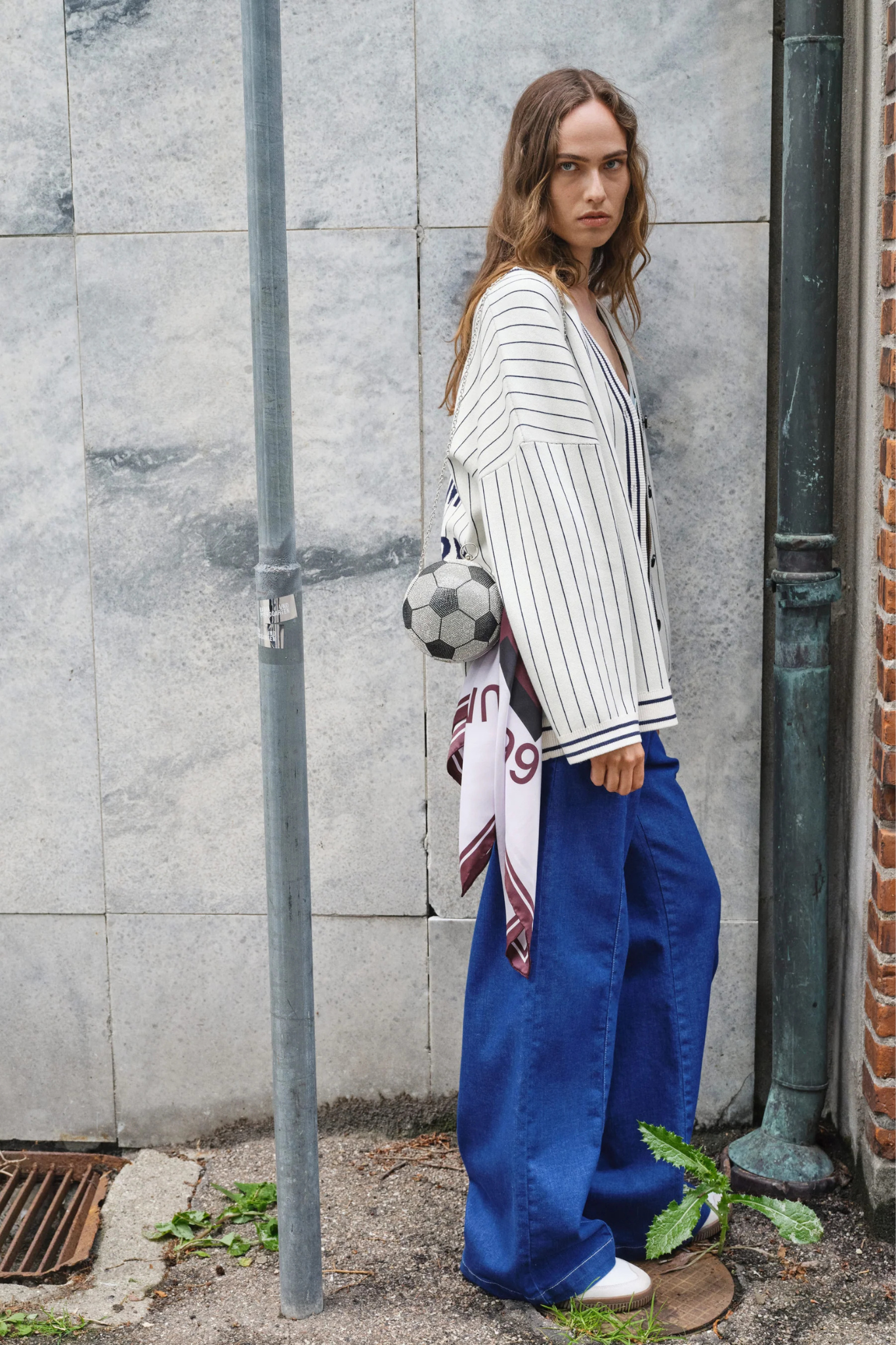 Model wearing the Baum Und Pferdgarten noiella jeans in blue. Side view