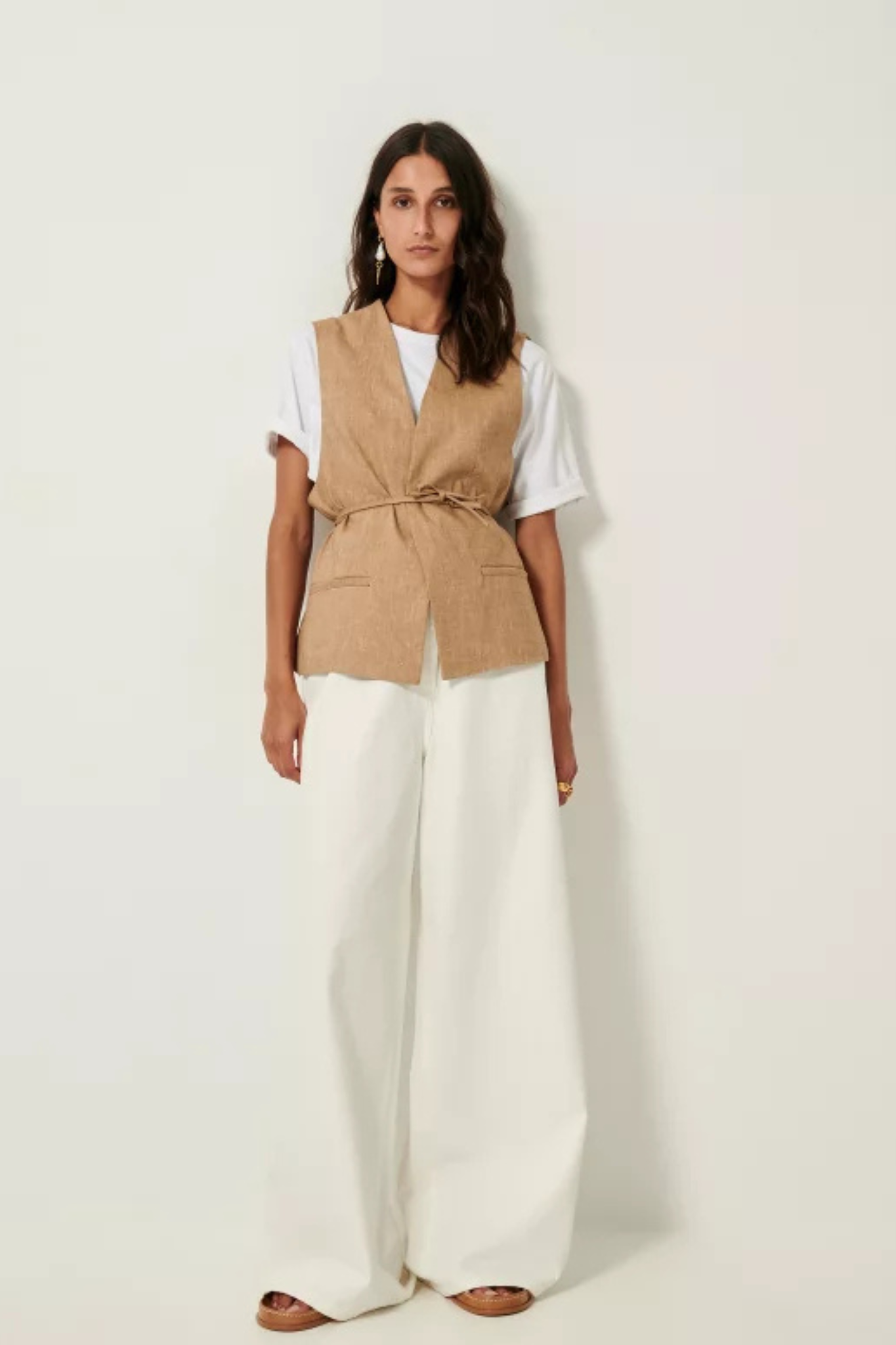 Model wearing the Sessun marcello sleeveless jacket in camel. Front view