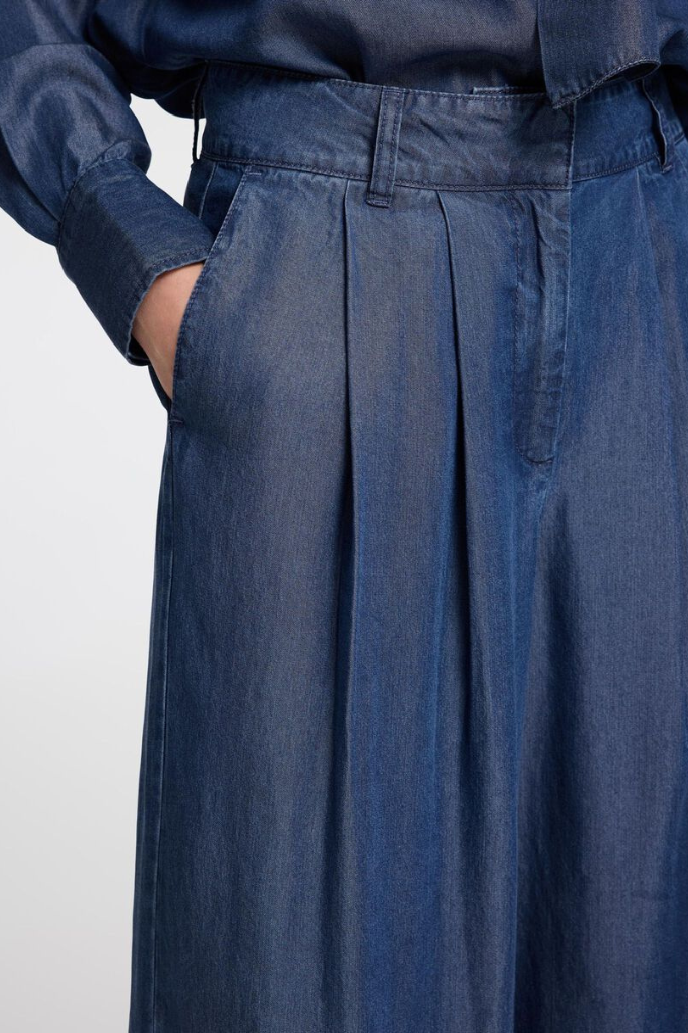 Model wearing the Selected Femme janna pleated chambray pants in dark blue. Close front view