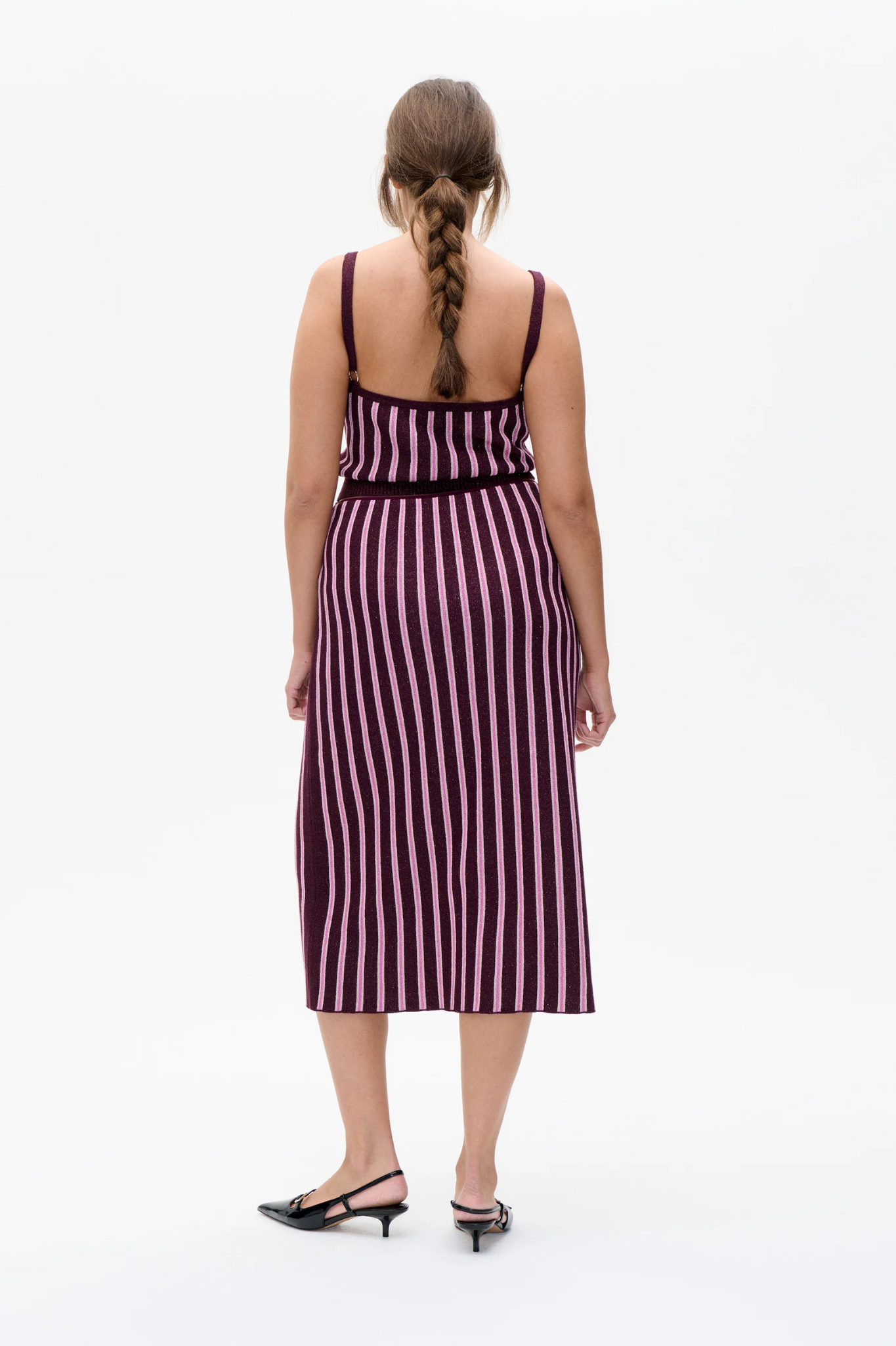 Model wearing the Baum Und Pferdgarten cypre top in purple and pink striped. Back view